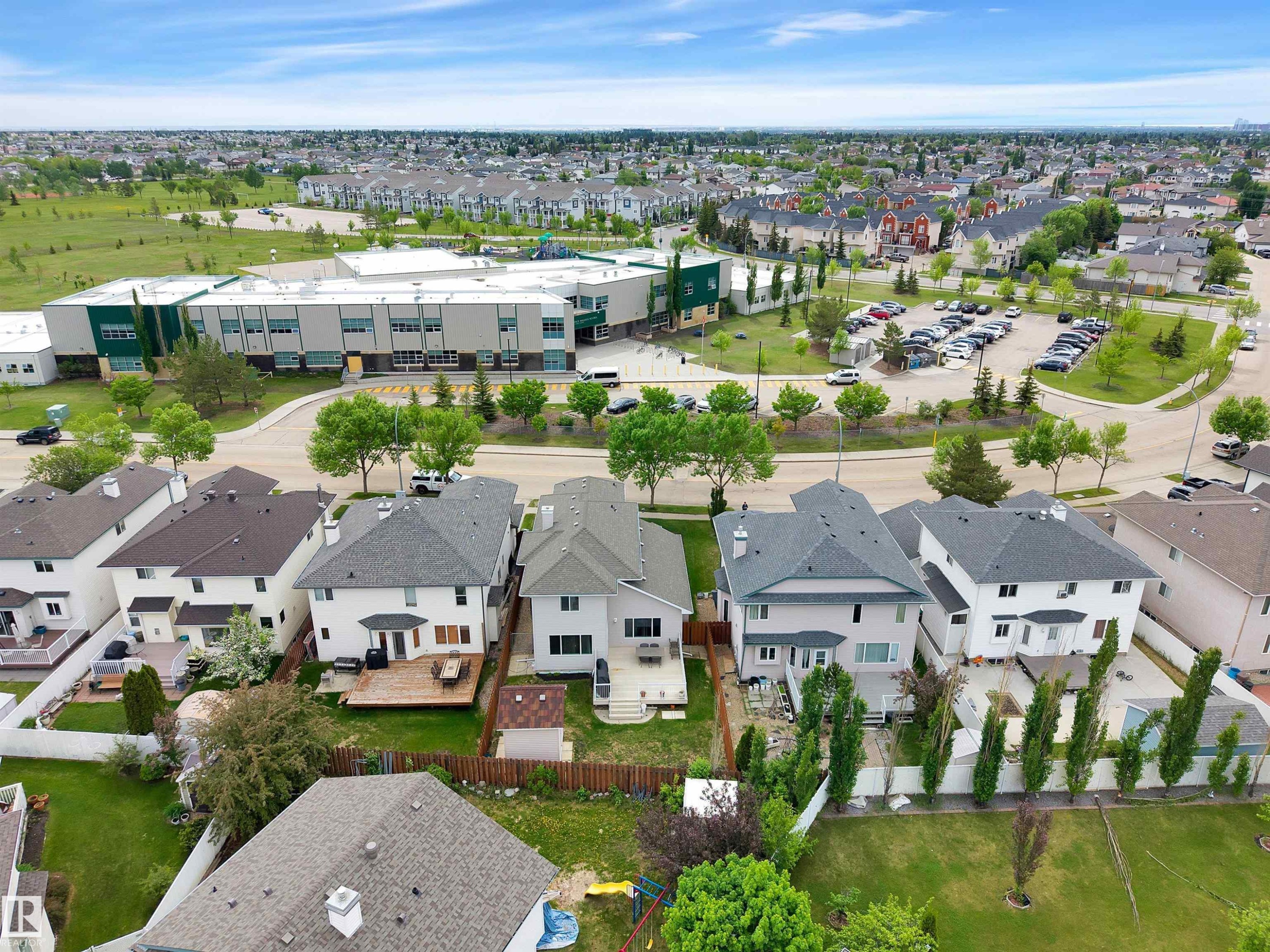 Aerial view showcasing the property's proximity to a contemporary school building with a large parking area - 16512 87 Street Nw, Edmonton, AB - Outdoor With View