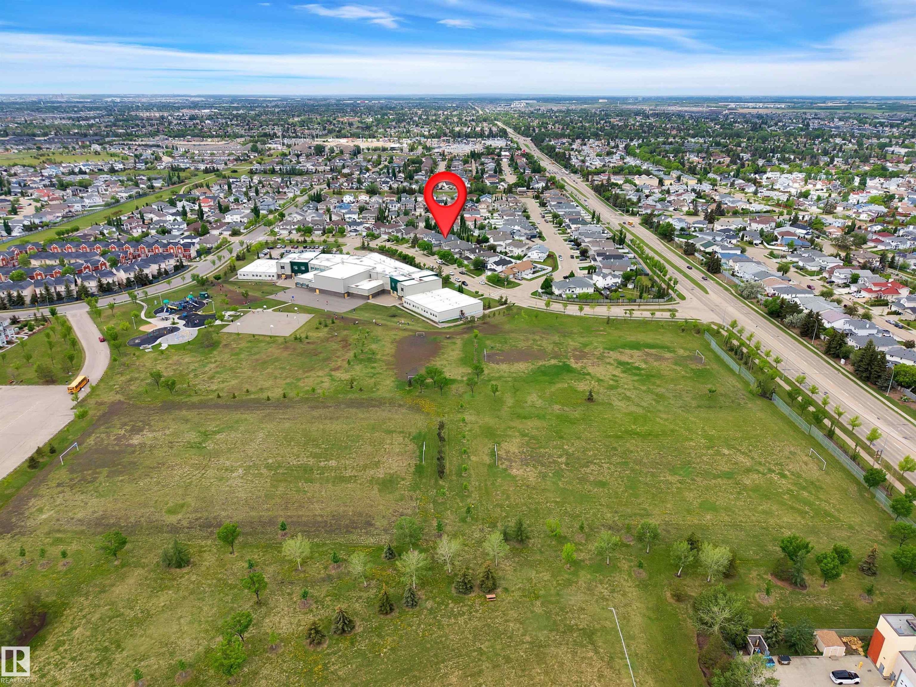 Aerial perspective showcasing a residential area with a prominent school building and expansive green spaces - 16512 87 Street Nw, Edmonton, AB - Outdoor With View