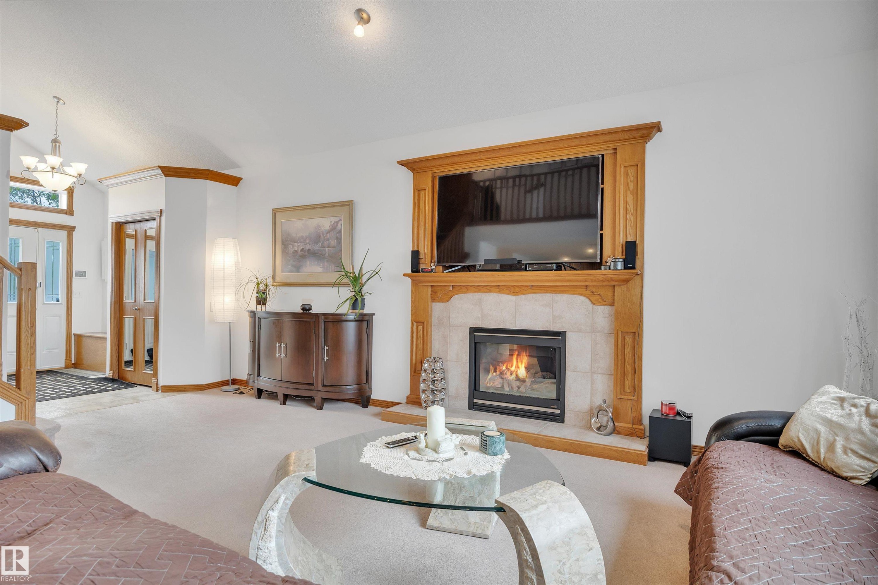Living area featuring a fireplace with a wood-finish mantel and tile surround - 16512 87 Street Nw, Edmonton, AB - Indoor Photo Showing Living Room With Fireplace