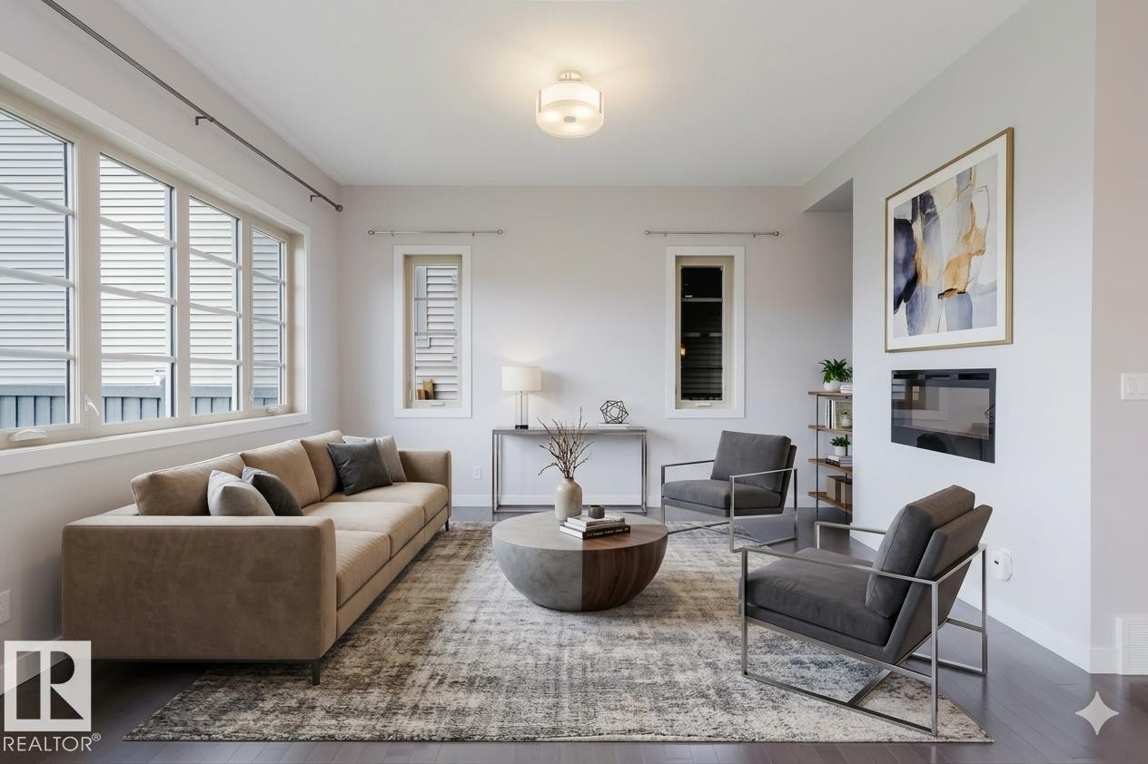 Living area featuring dark wood-finish flooring, multiple paneled windows, a built-in wall-mounted fireplace, and recessed ceiling lighting - 2921 Anderson Crest Sw, Edmonton, AB - Indoor Photo Showing Living Room