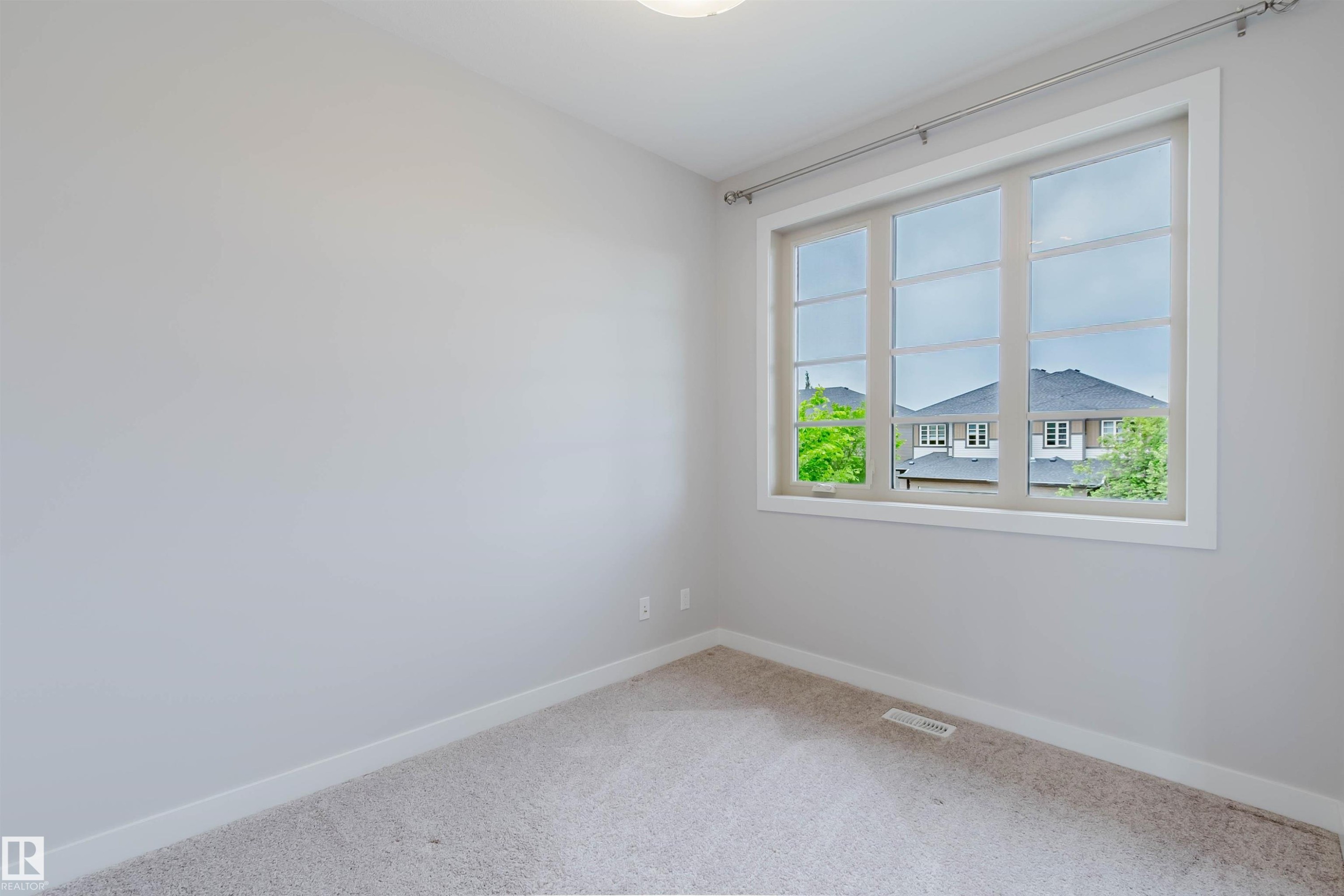 Carpeted room with light gray walls, a large multi-pane window, and white trim - 2921 Anderson Crest Sw, Edmonton, AB - Indoor Photo Showing Other Room