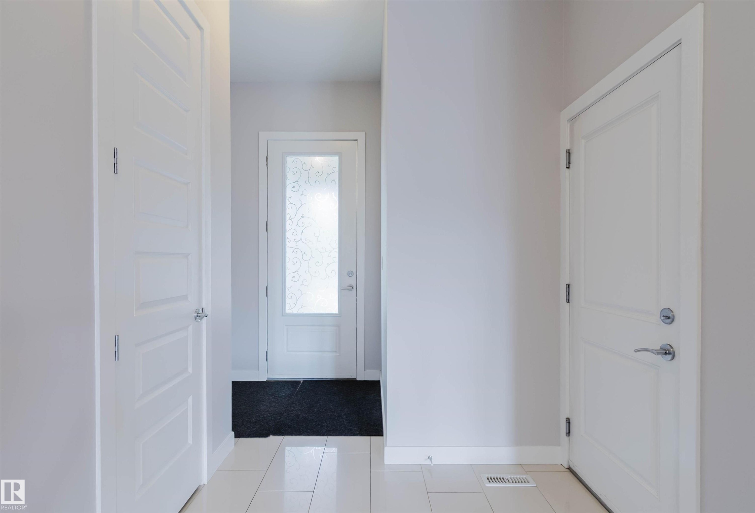 Entryway featuring white panel doors, light-toned wall paint, and glossy tile flooring - 2921 Anderson Crest Sw, Edmonton, AB - Indoor Photo Showing Other Room