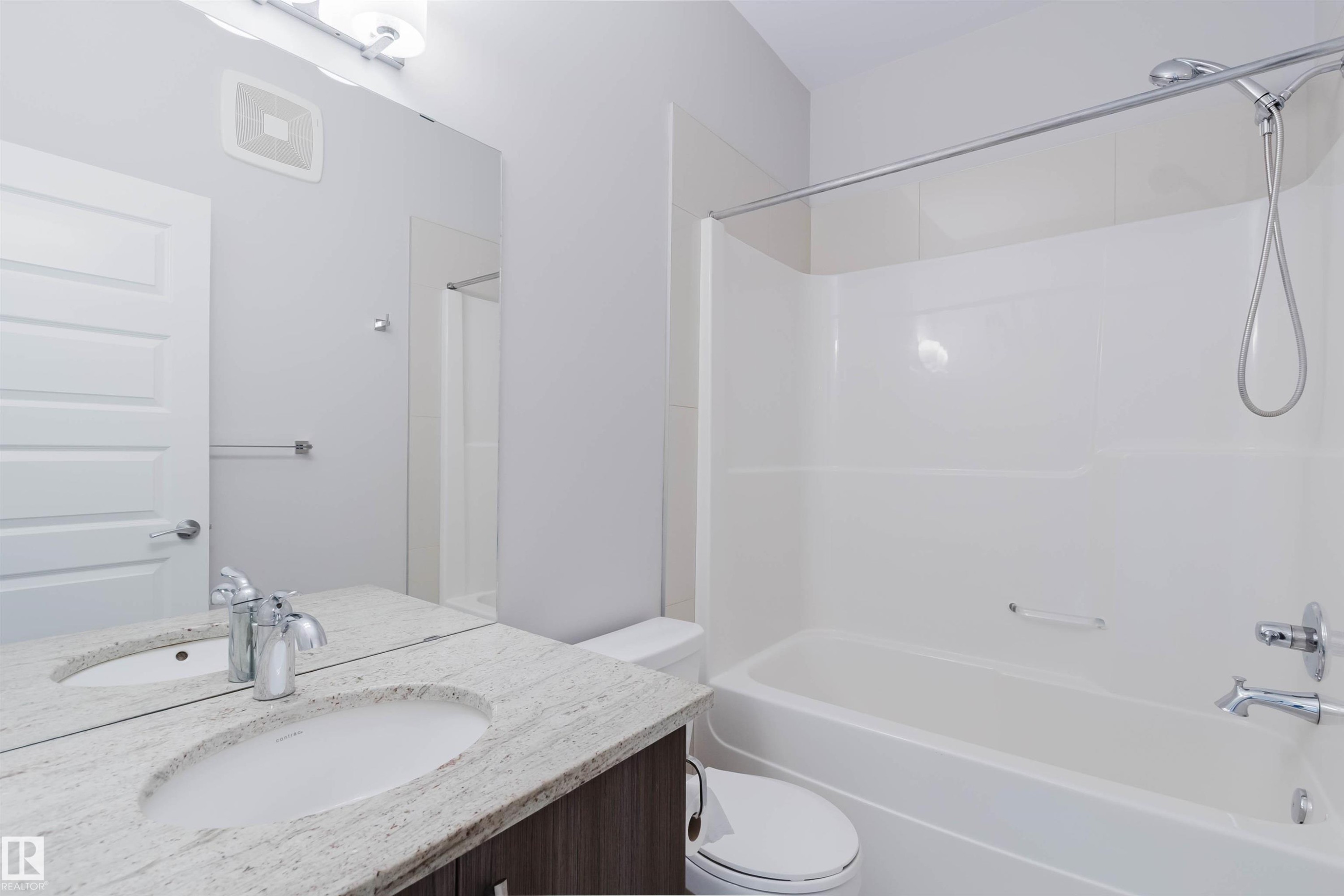 Full bathroom featuring a white tub/shower combination, chrome fixtures, a wood-finish vanity with a light-colored countertop, and a large wall-mounted mirror - 2921 Anderson Crest Sw, Edmonton, AB - Indoor Photo Showing Bathroom