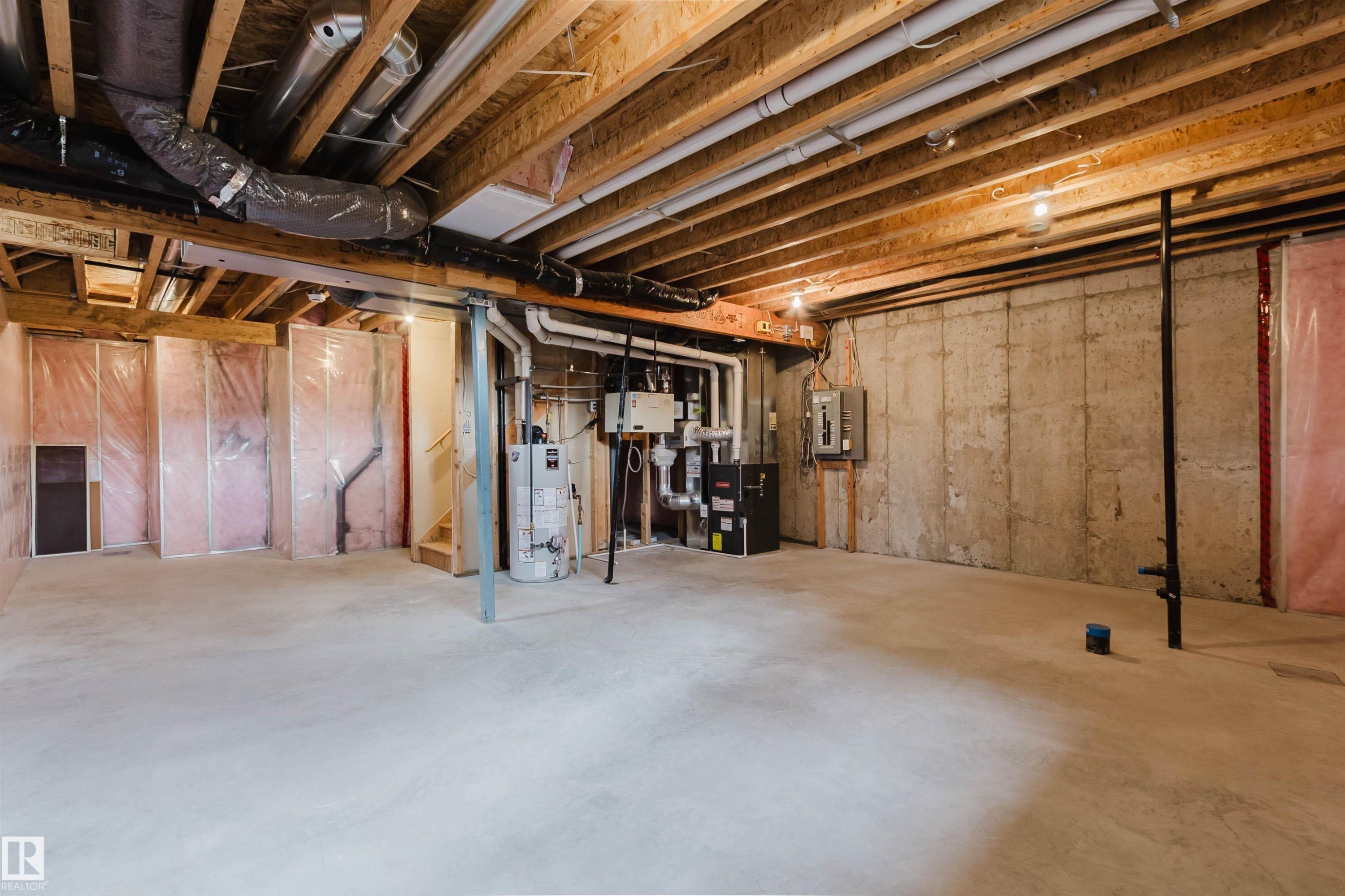 Unfinished lower level featuring exposed ceiling joists, concrete flooring, and insulated wall framing - 2921 Anderson Crest Sw, Edmonton, AB - Indoor Photo Showing Basement