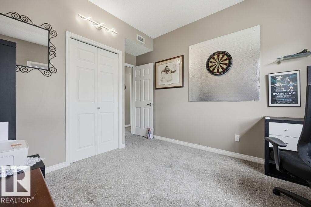 Carpeted room featuring a white bi-fold closet, neutral wall paint, and white baseboards - 71 3040 Spence Wynd, Edmonton, AB