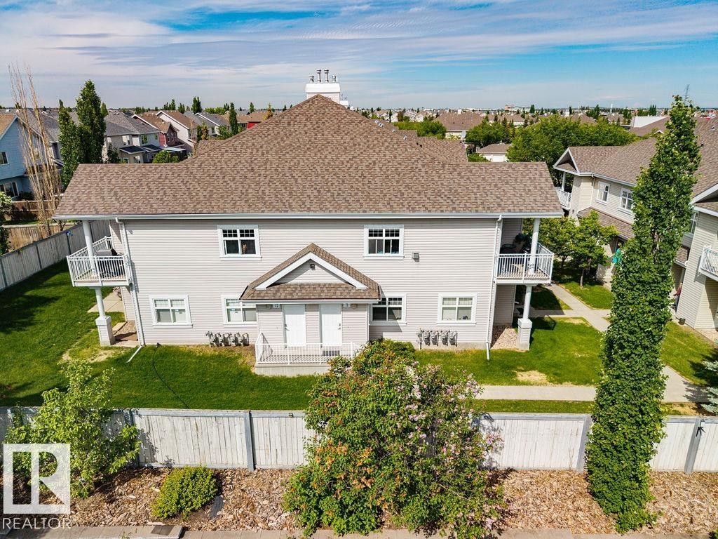 Two-story property featuring light-colored siding and a gabled roof - 71 3040 Spence Wynd, Edmonton, AB