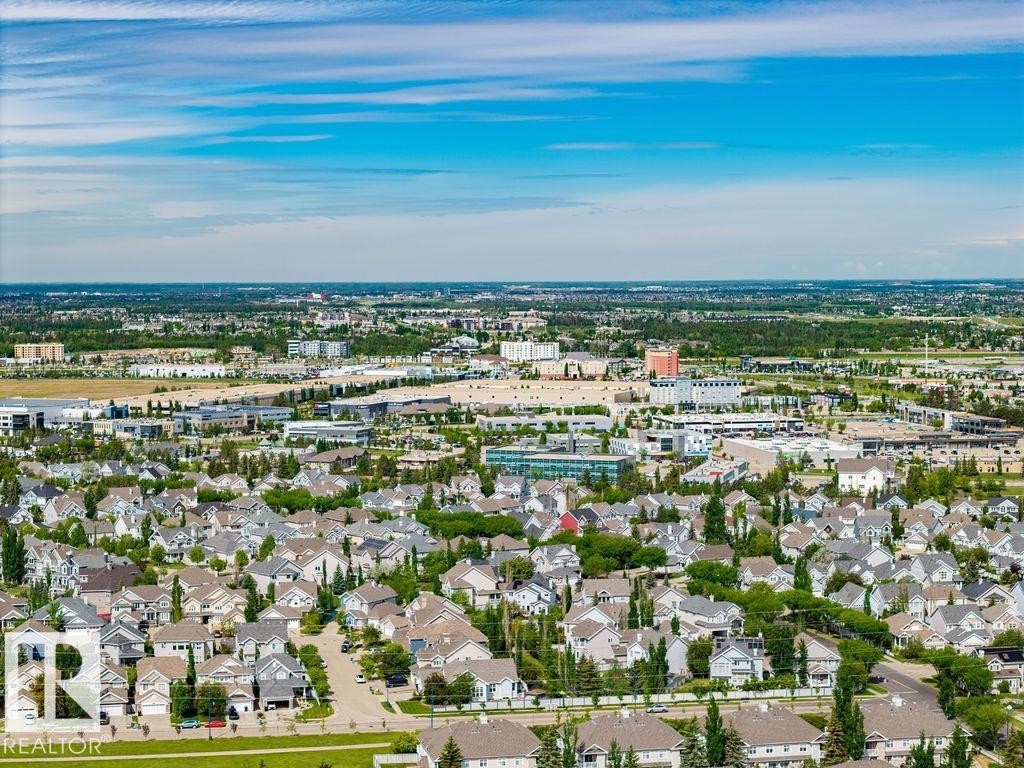 Expansive aerial perspective showcasing a residential neighborhood with numerous single-family homes and mature trees - 71 3040 Spence Wynd, Edmonton, AB