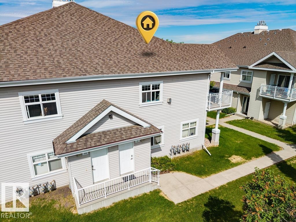 Exterior featuring light-colored siding, multiple windows, and a brown shingle roof - 71 3040 Spence Wynd, Edmonton, AB