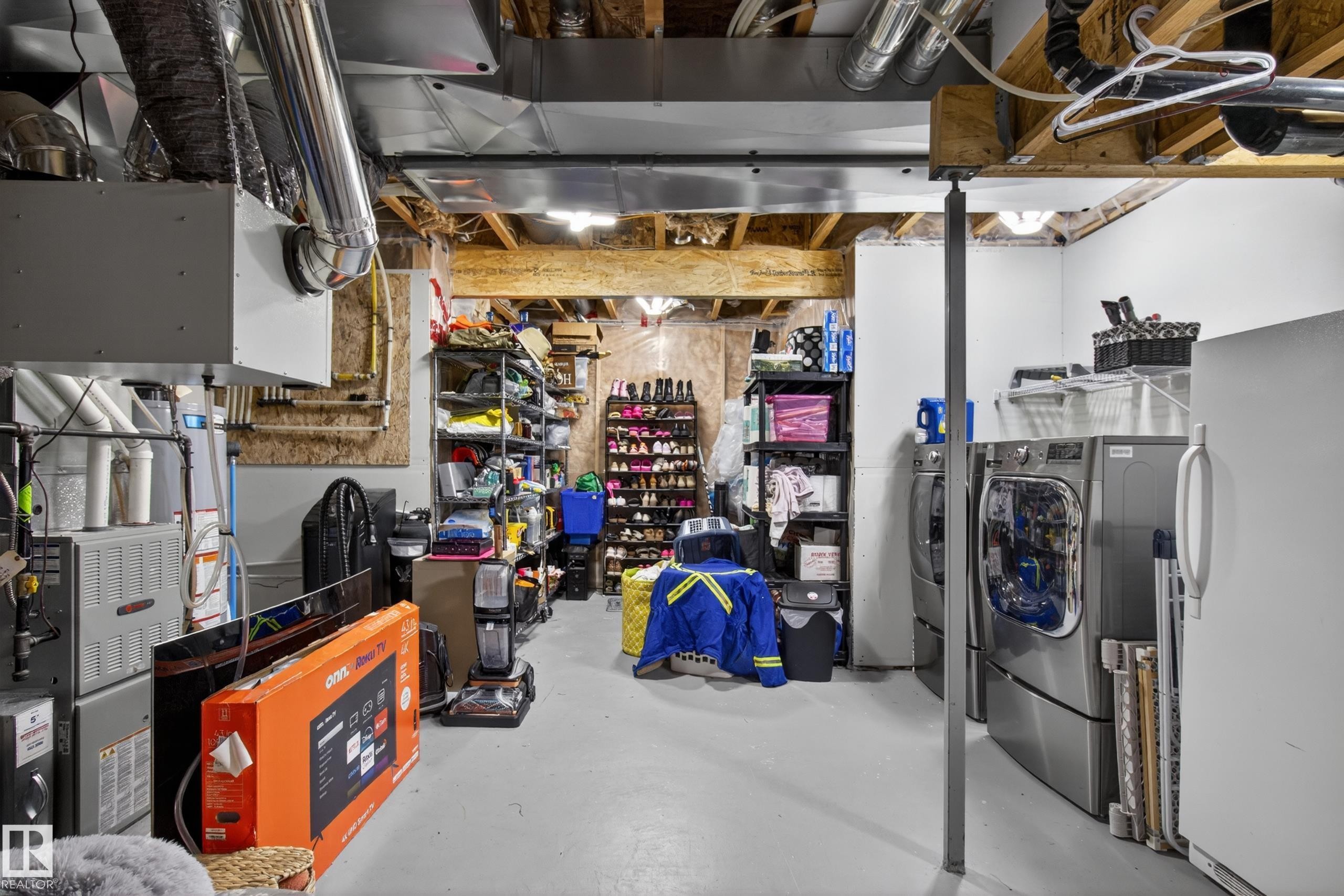 Utility area featuring exposed ceiling joists, ductwork, and a concrete floor - 9847 220 Street, Edmonton, AB
