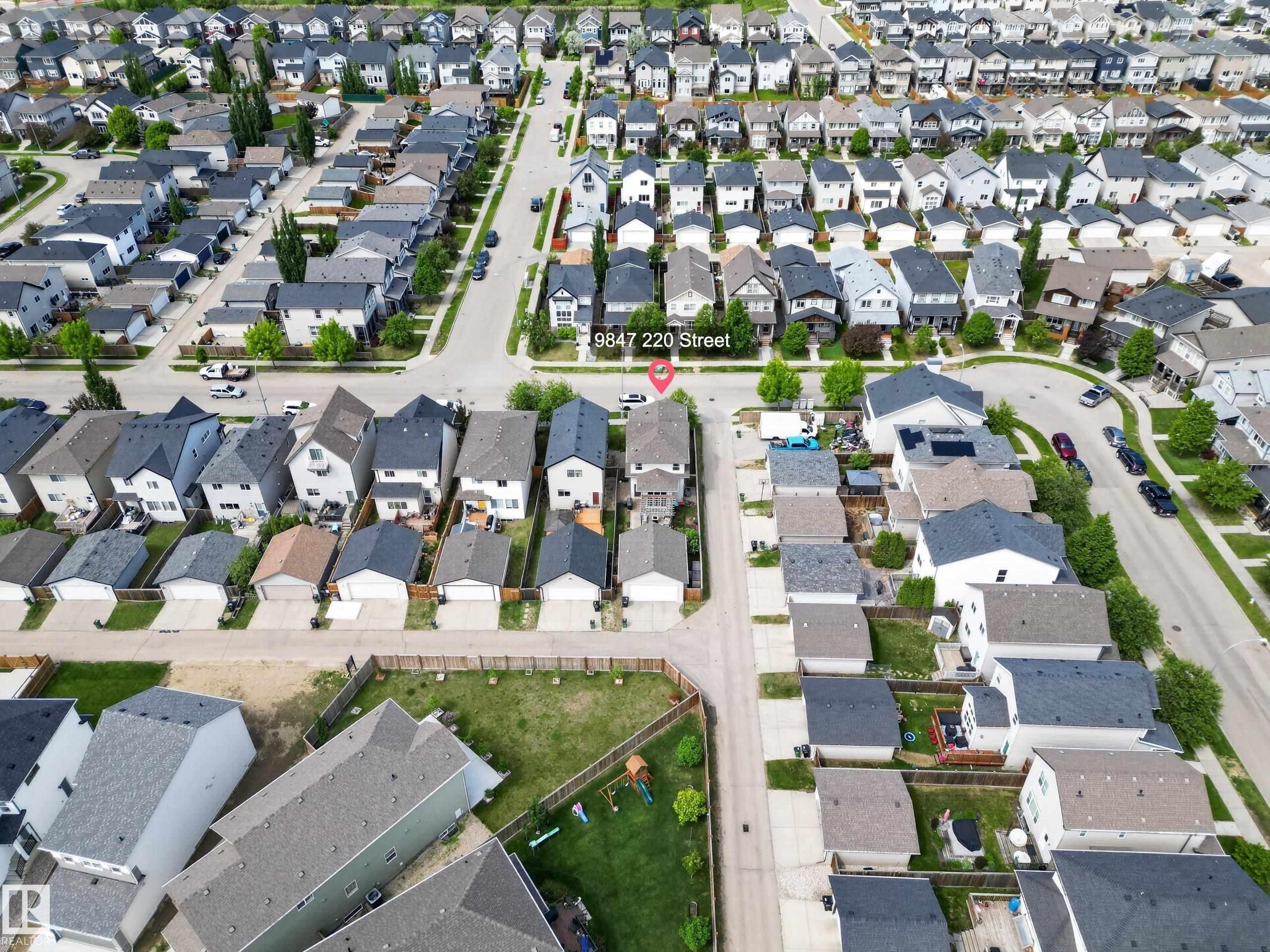 Aerial view showcasing a residential street with uniform contemporary homes and detached garages - 9847 220 Street, Edmonton, AB
