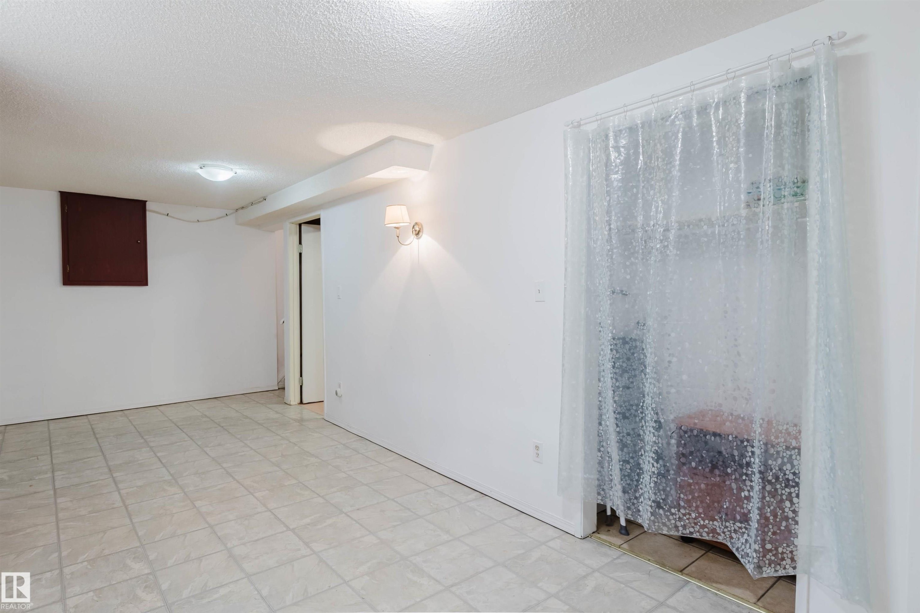 Finished room featuring neutral wall paint, tile flooring, and a flush-mount ceiling light - 4 14310 80 Street, Edmonton, AB