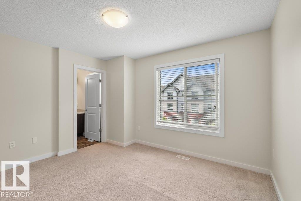Expansive room featuring neutral-toned carpeting and light-colored walls - 125 655 Watt Boulevard, Edmonton, AB