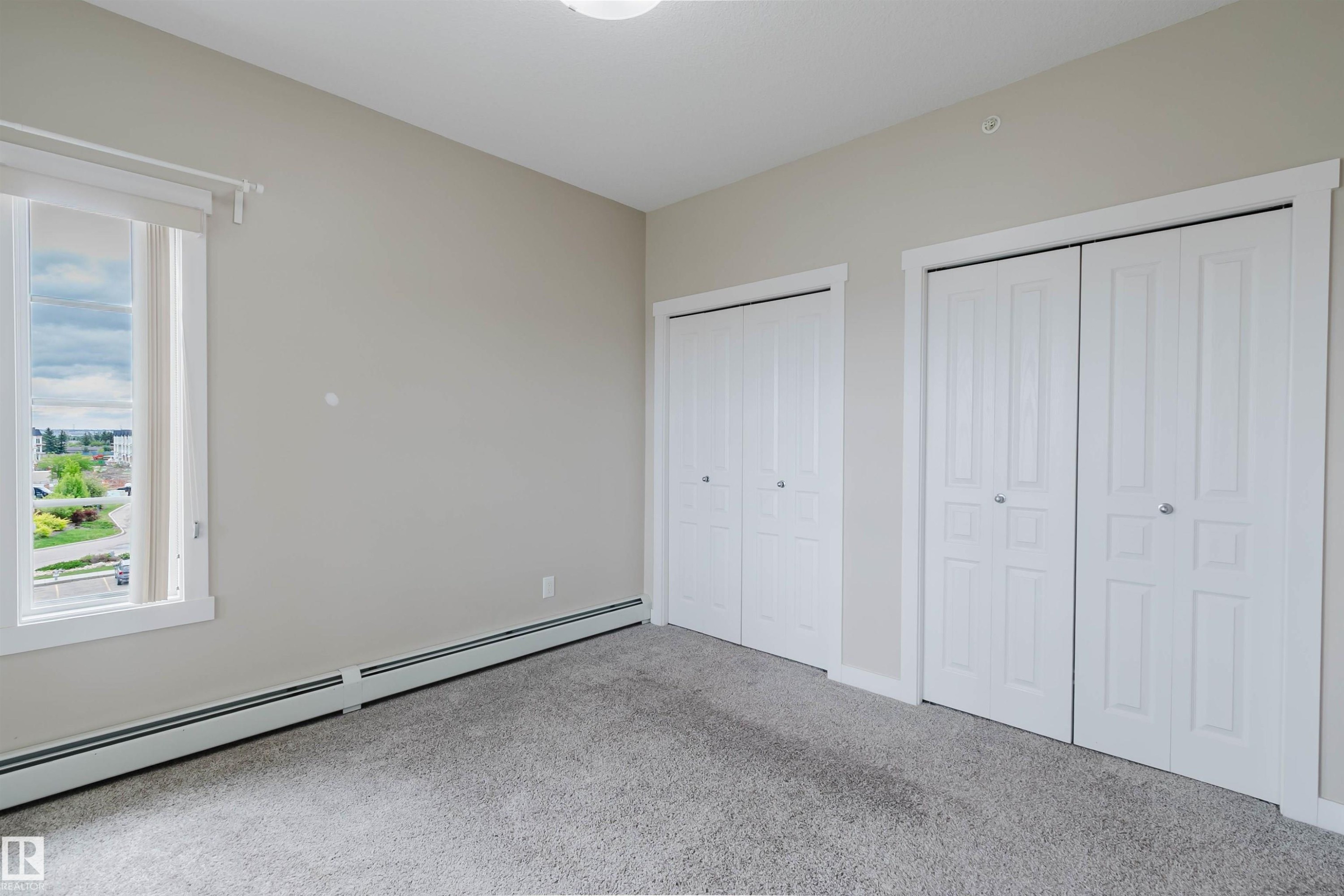 Neutral-toned room featuring light gray walls and plush gray carpeting - 402 3670 139 Avenue, Edmonton, AB