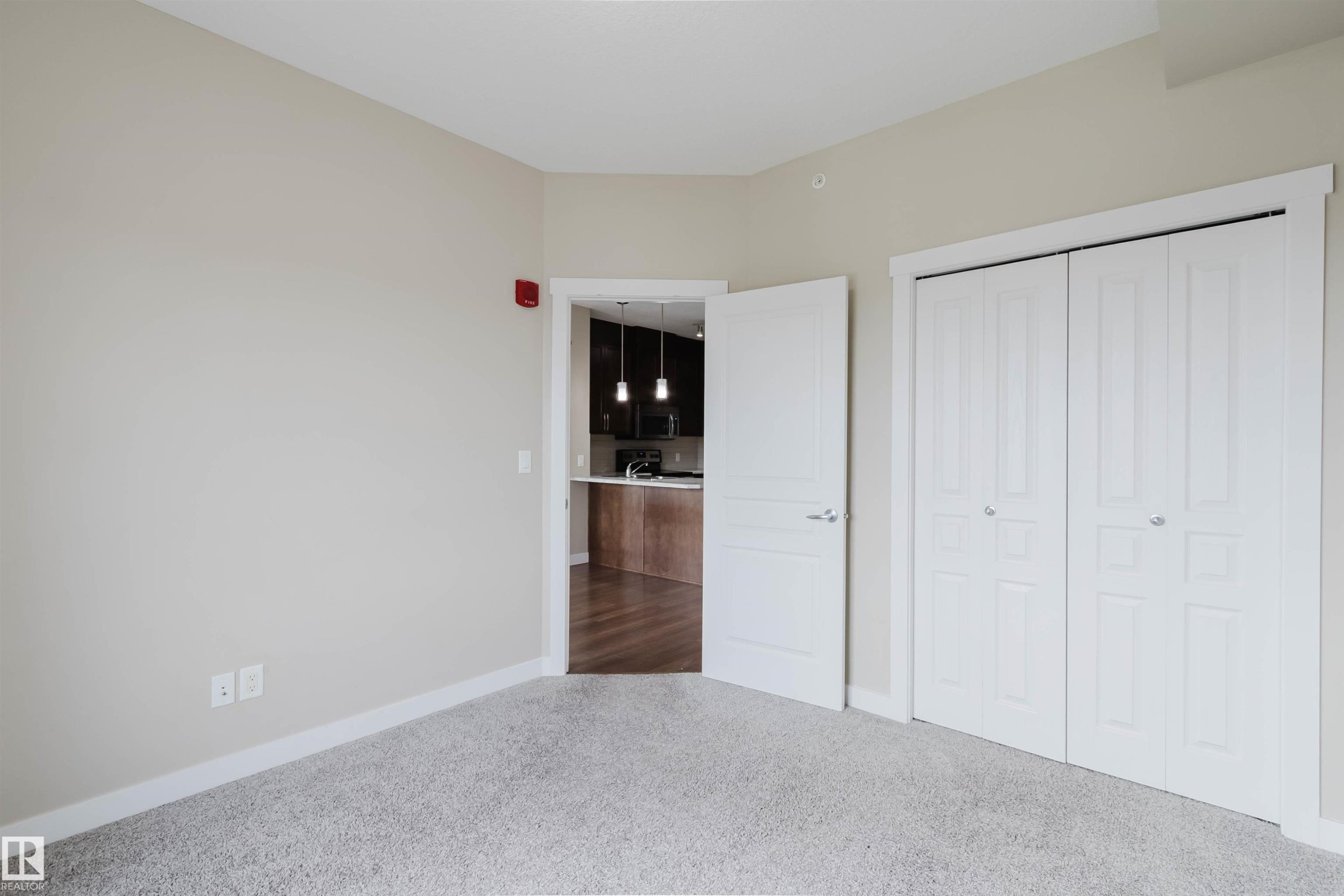 Neutral-toned room featuring light gray carpet flooring and white trim - 402 3670 139 Avenue, Edmonton, AB