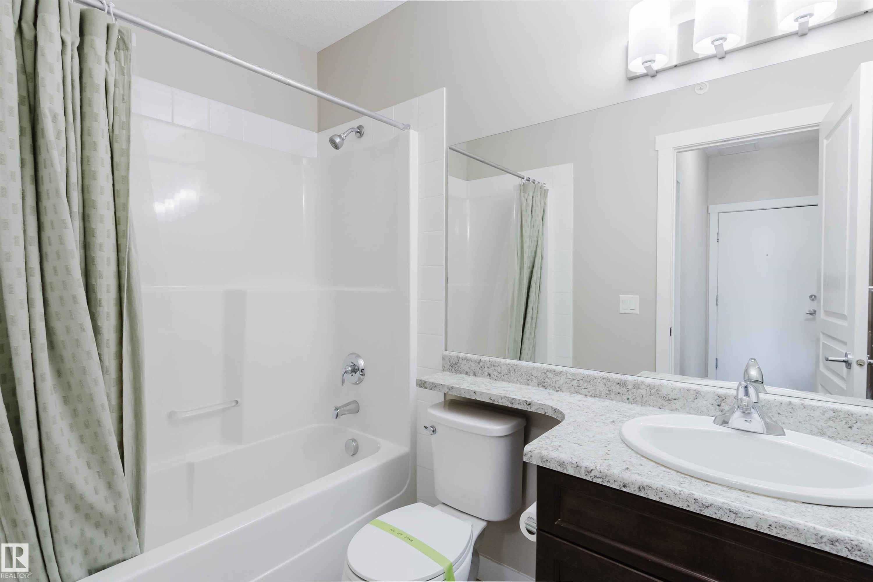 Bathroom featuring a white bathtub and shower combination with chrome fixtures - 402 3670 139 Avenue, Edmonton, AB