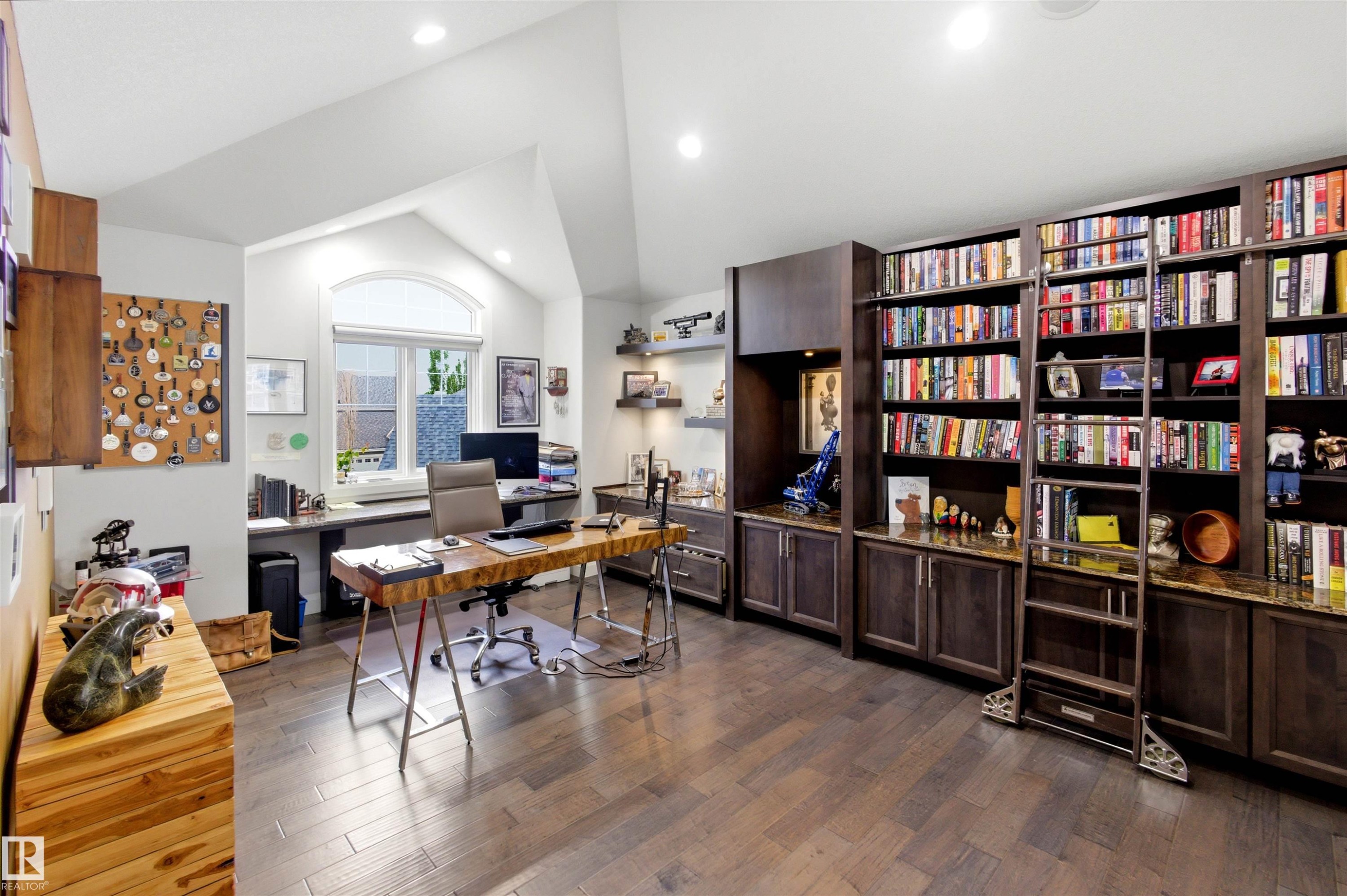 Dedicated room featuring extensive built-in shelving, wood-finish flooring, recessed lighting, and a window with an arched transom - 9003 16 Avenue Sw, Edmonton, AB - Indoor Photo Showing Office
