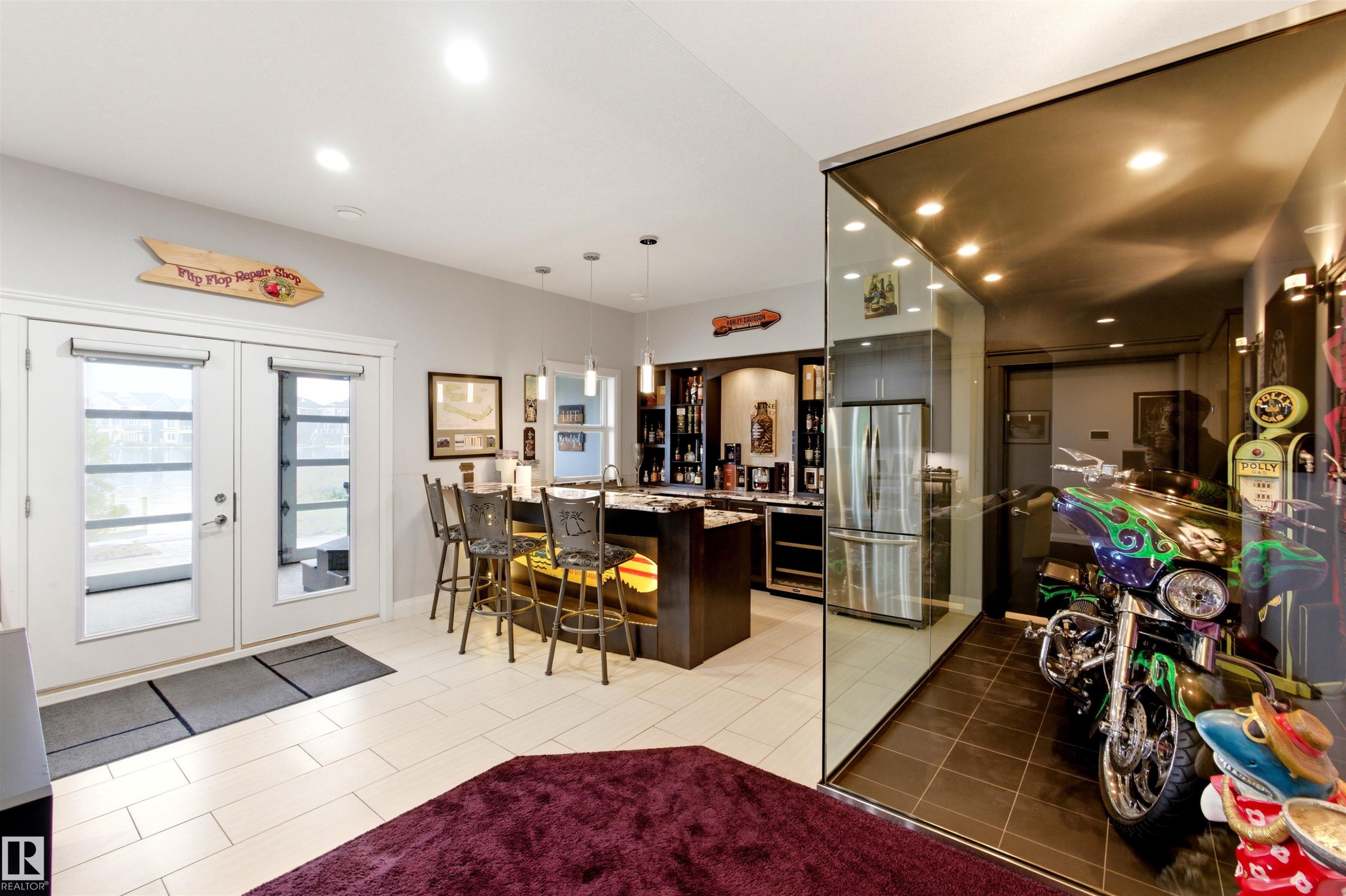 Recreational room featuring a built-in wet bar, stainless steel refrigerator, and glass-encased display area - 9003 16 Avenue Sw, Edmonton, AB - Indoor Photo Showing Dining Room