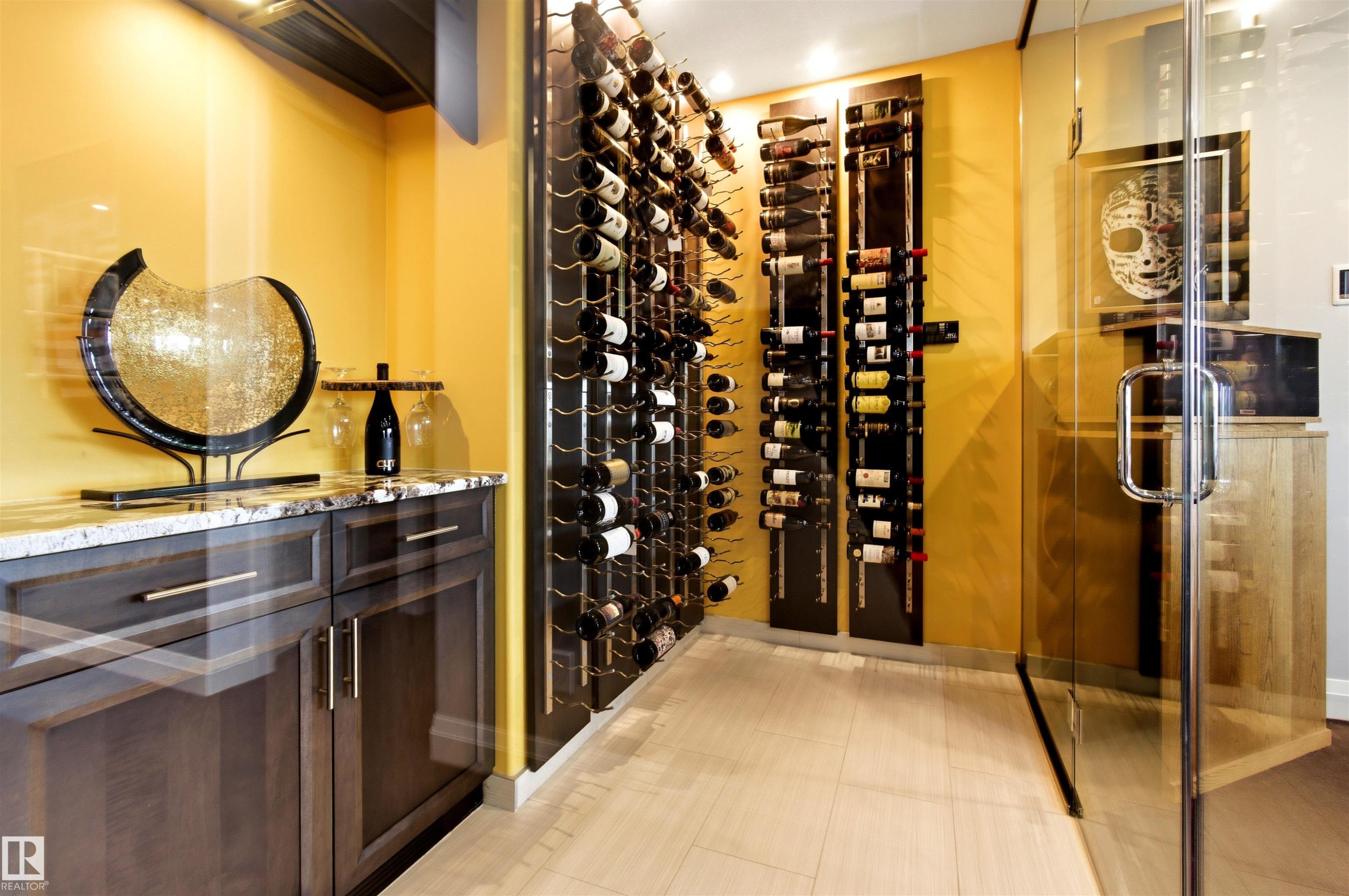 Custom wine storage area featuring glass enclosure, built-in shelving for bottle display, and wood-finish flooring - 9003 16 Avenue Sw, Edmonton, AB - Indoor