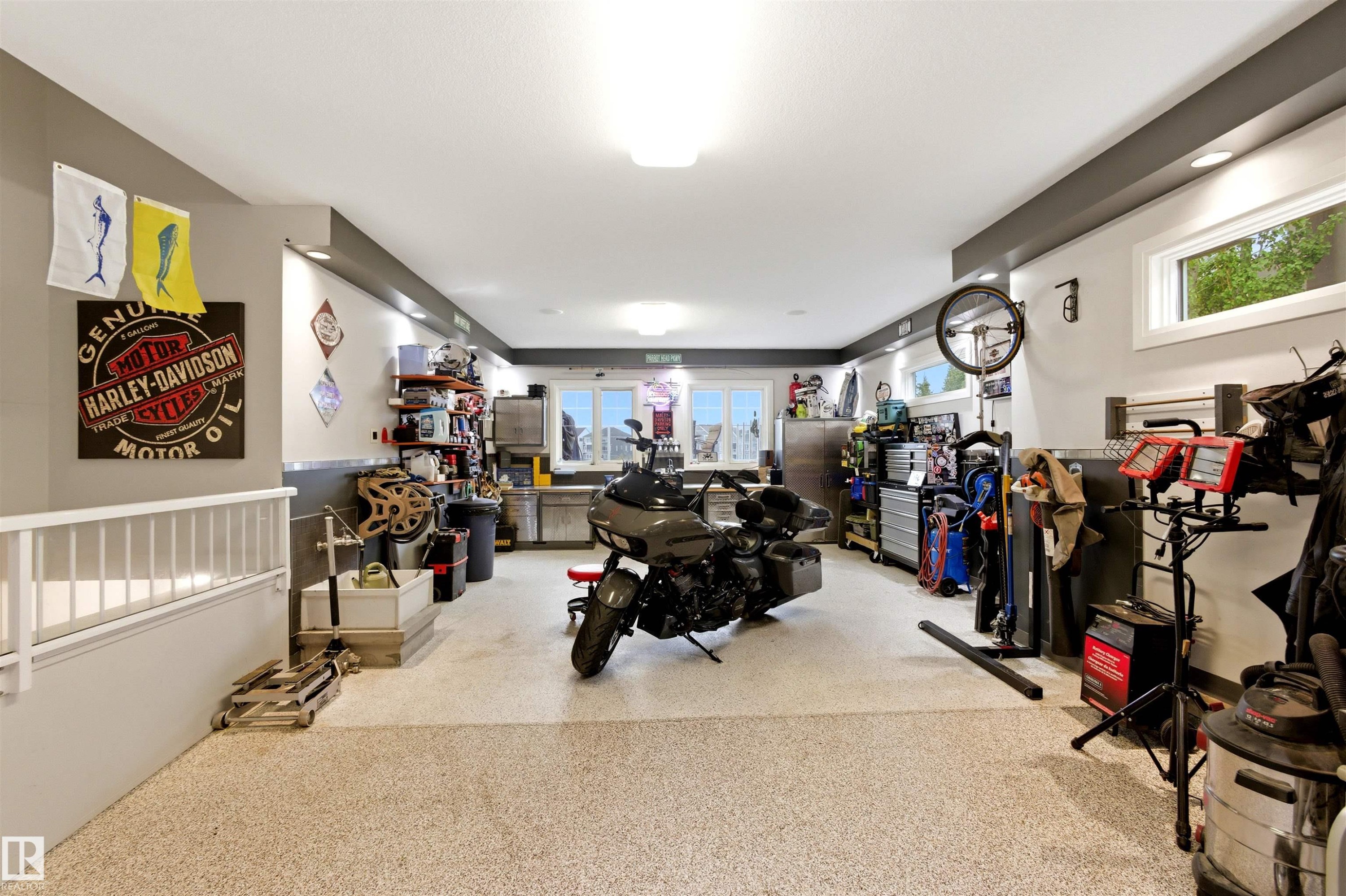 Spacious garage featuring a durable speckled epoxy floor, recessed lighting, and multiple windows for natural illumination - 9003 16 Avenue Sw, Edmonton, AB - Indoor Photo Showing Other Room