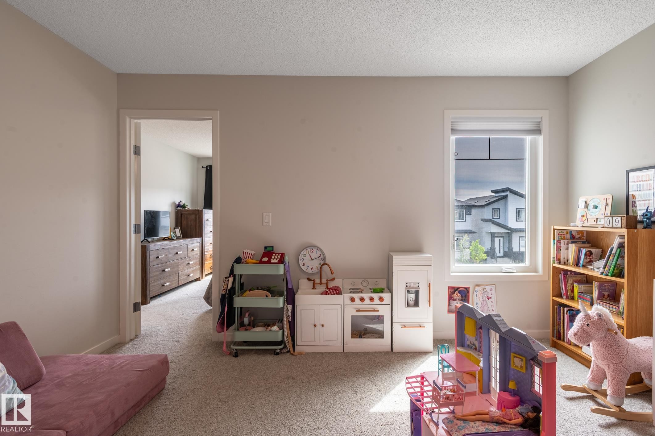 Carpeted room featuring a white-trimmed window, neutral wall paint, and a standard doorway - 17562 63A Street, Edmonton, AB