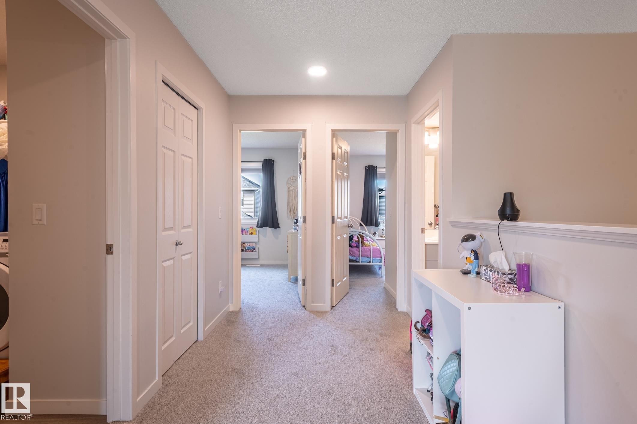 Carpeted hallway featuring a neutral color palette, recessed lighting, and multiple paneled doors - 17562 63A Street, Edmonton, AB