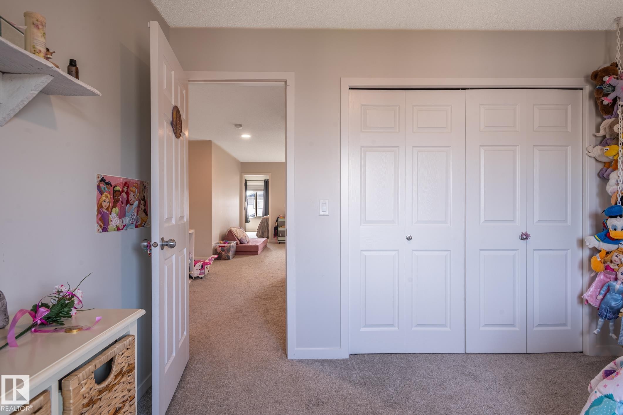 White bi-fold closet doors with panel detailing, light neutral wall paint, and plush carpeting - 17562 63A Street, Edmonton, AB