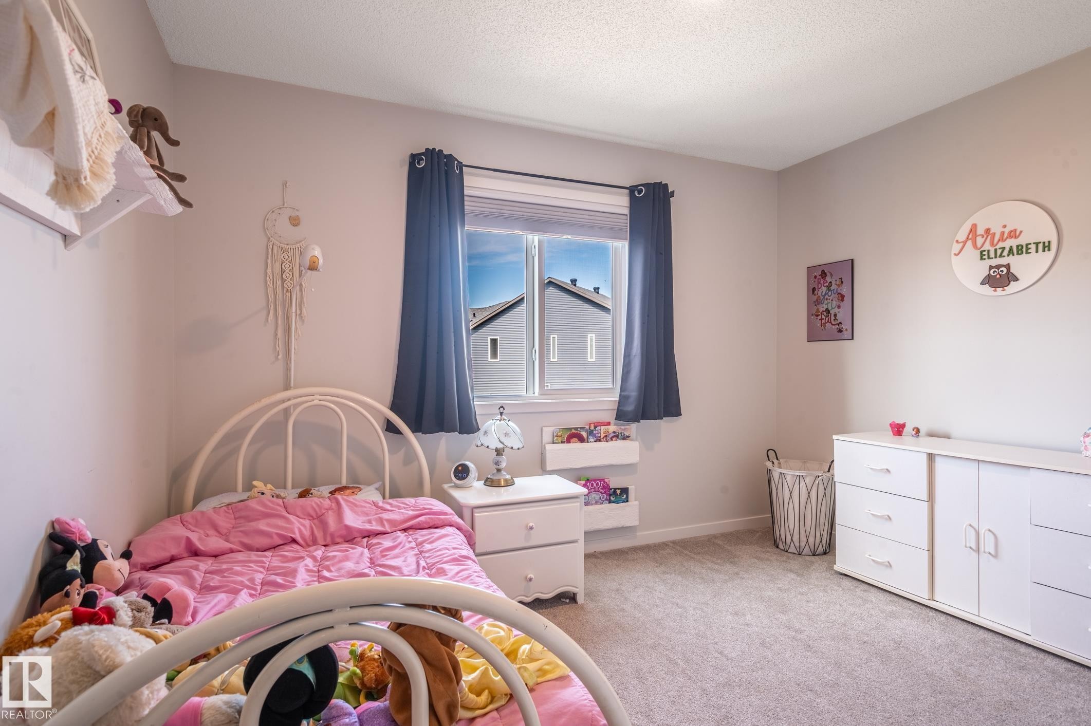 Bright interior room featuring a window with dark curtains, light-colored walls, and neutral-toned carpeting - 17562 63A Street, Edmonton, AB