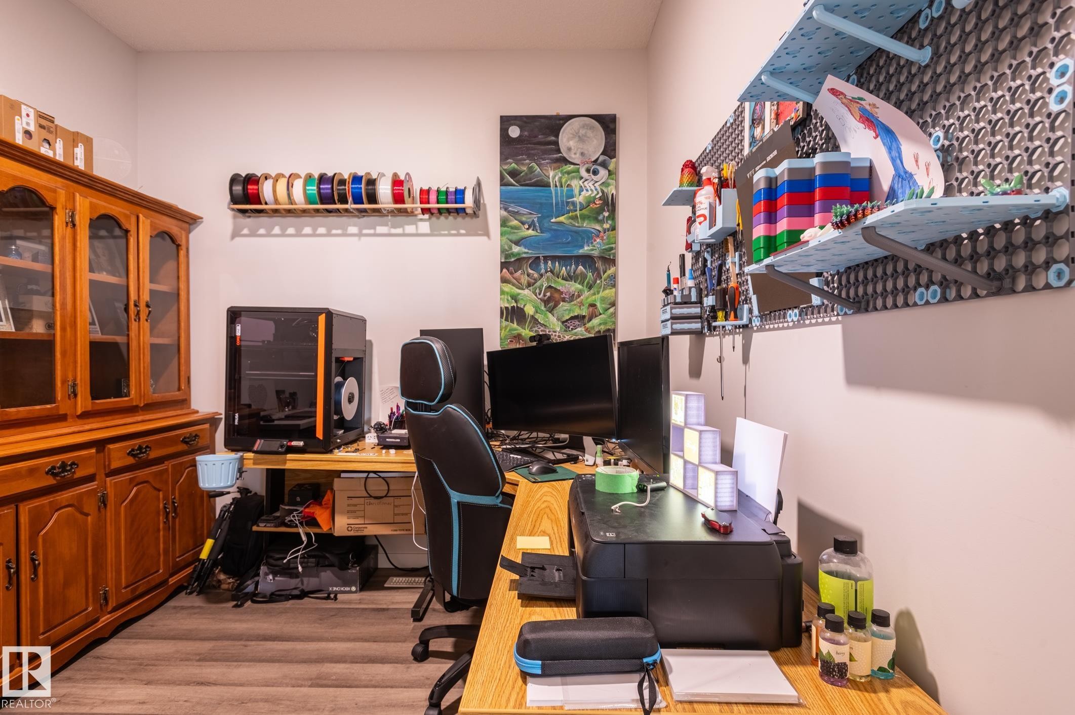 Wood-finish flooring anchors this versatile space, featuring light-toned walls and built-in wall shelving - 17562 63A Street, Edmonton, AB