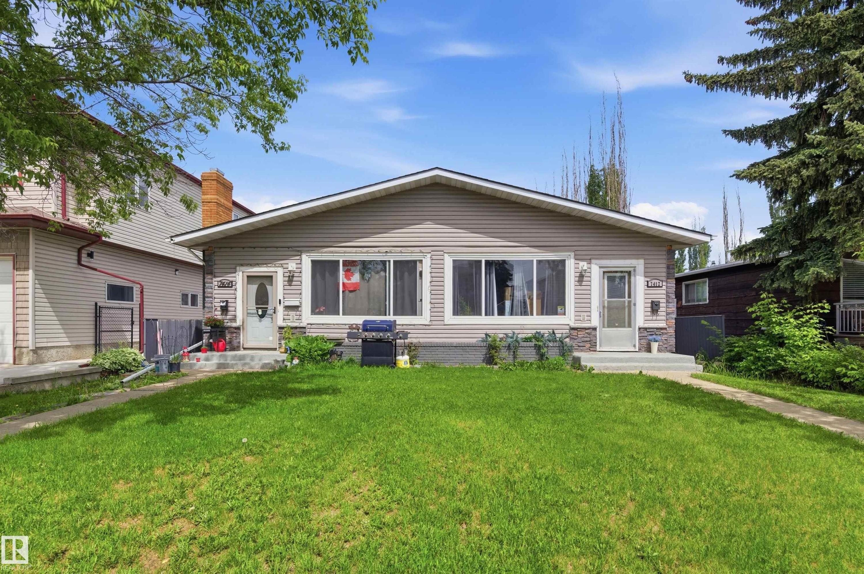 Ranch-style exterior with light-toned siding and stone veneer accents - 7412/7414 83 Avenue Nw, Edmonton, AB - Outdoor