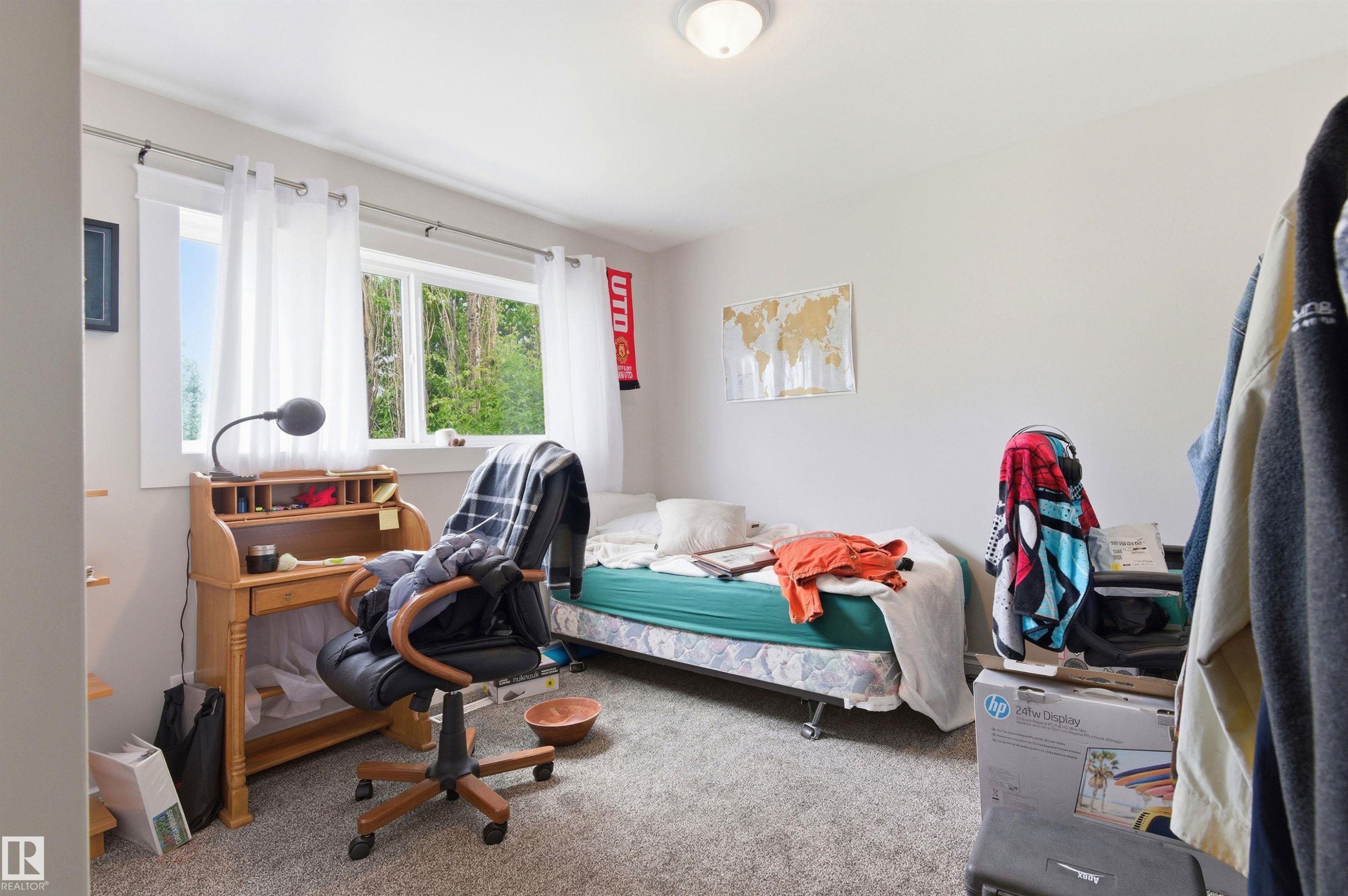 Wall-to-wall carpeting and white walls enhance this room, featuring two large windows - 7412/7414 83 Avenue Nw, Edmonton, AB - Indoor Photo Showing Bedroom