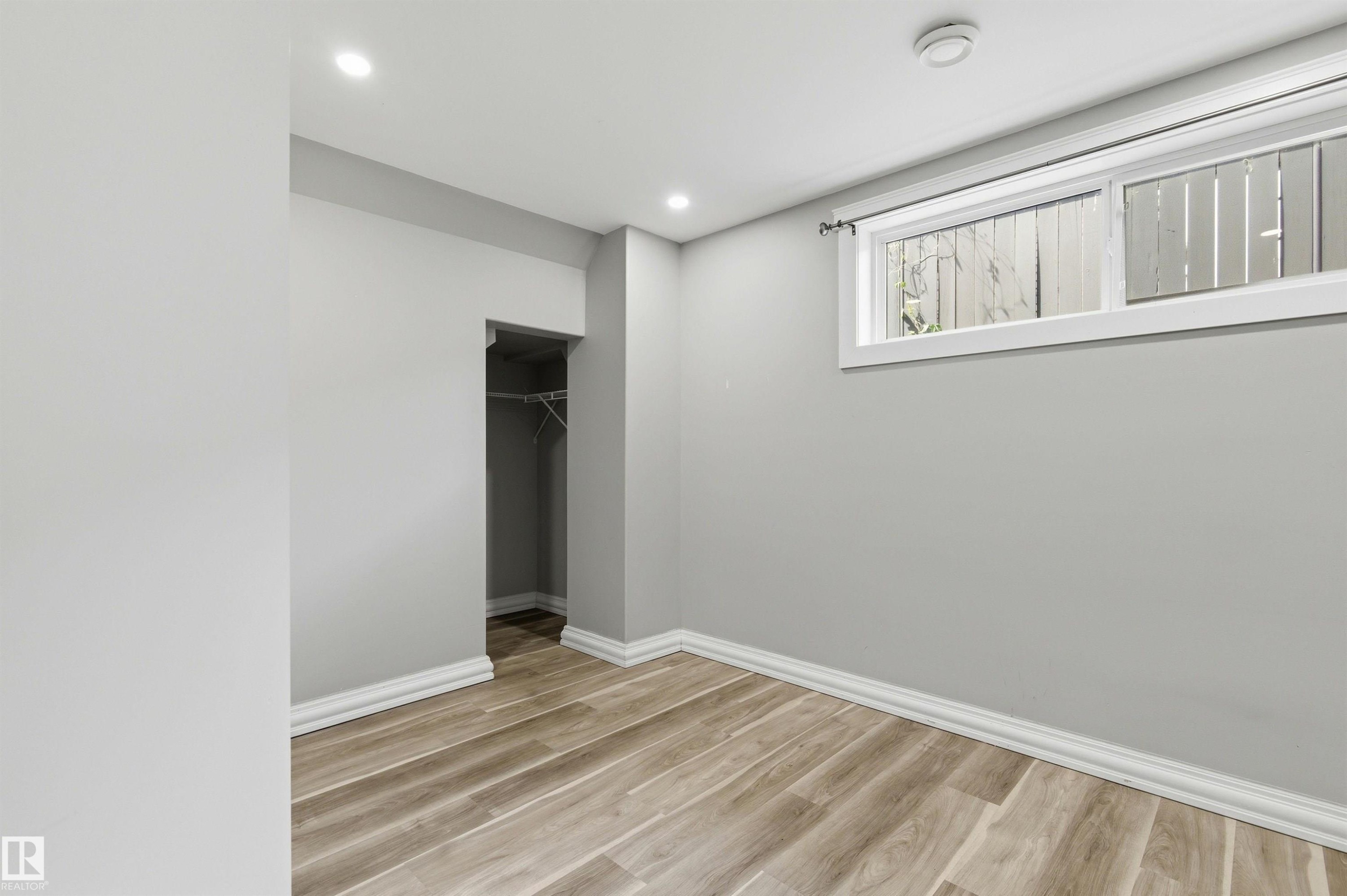 Room featuring wood-finish flooring, recessed lighting, and light grey wall finishes - 7412/7414 83 Avenue Nw, Edmonton, AB - Indoor Photo Showing Other Room