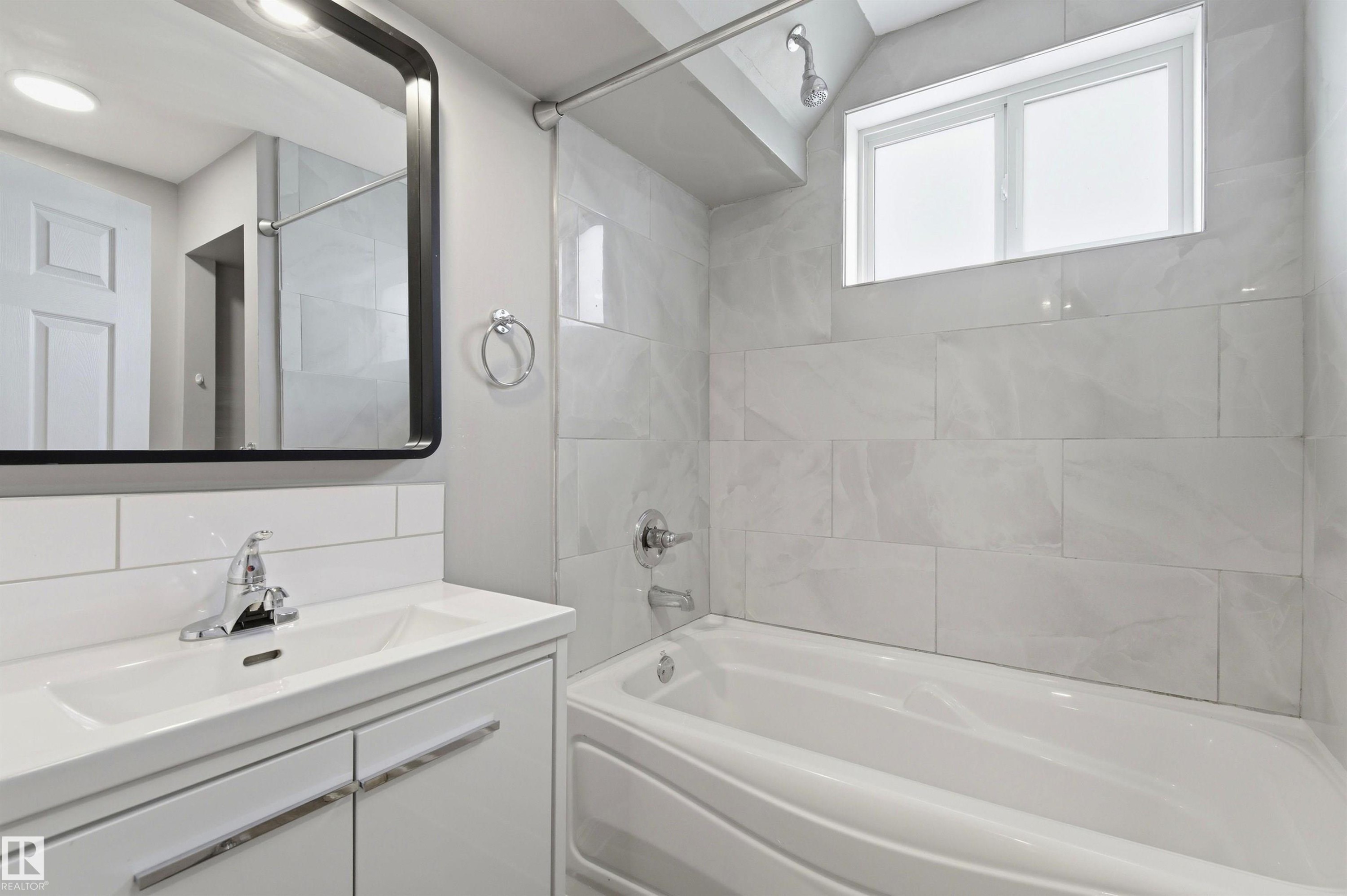 Modern bathroom vanity with integrated sink and chrome faucet - 7412/7414 83 Avenue Nw, Edmonton, AB - Indoor Photo Showing Bathroom