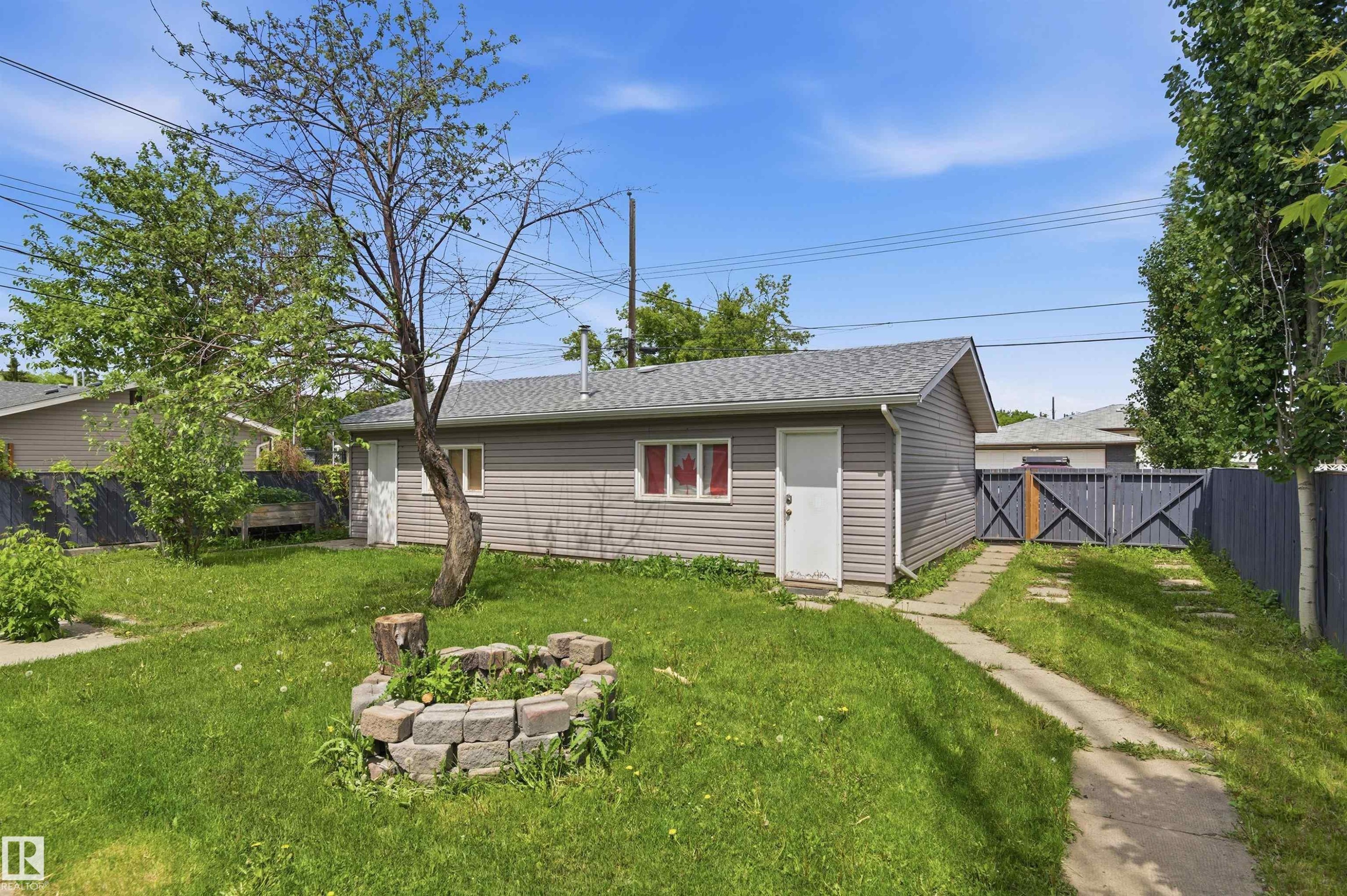Detached garage with horizontal siding and a gray shingle roof - 7412/7414 83 Avenue Nw, Edmonton, AB - Outdoor