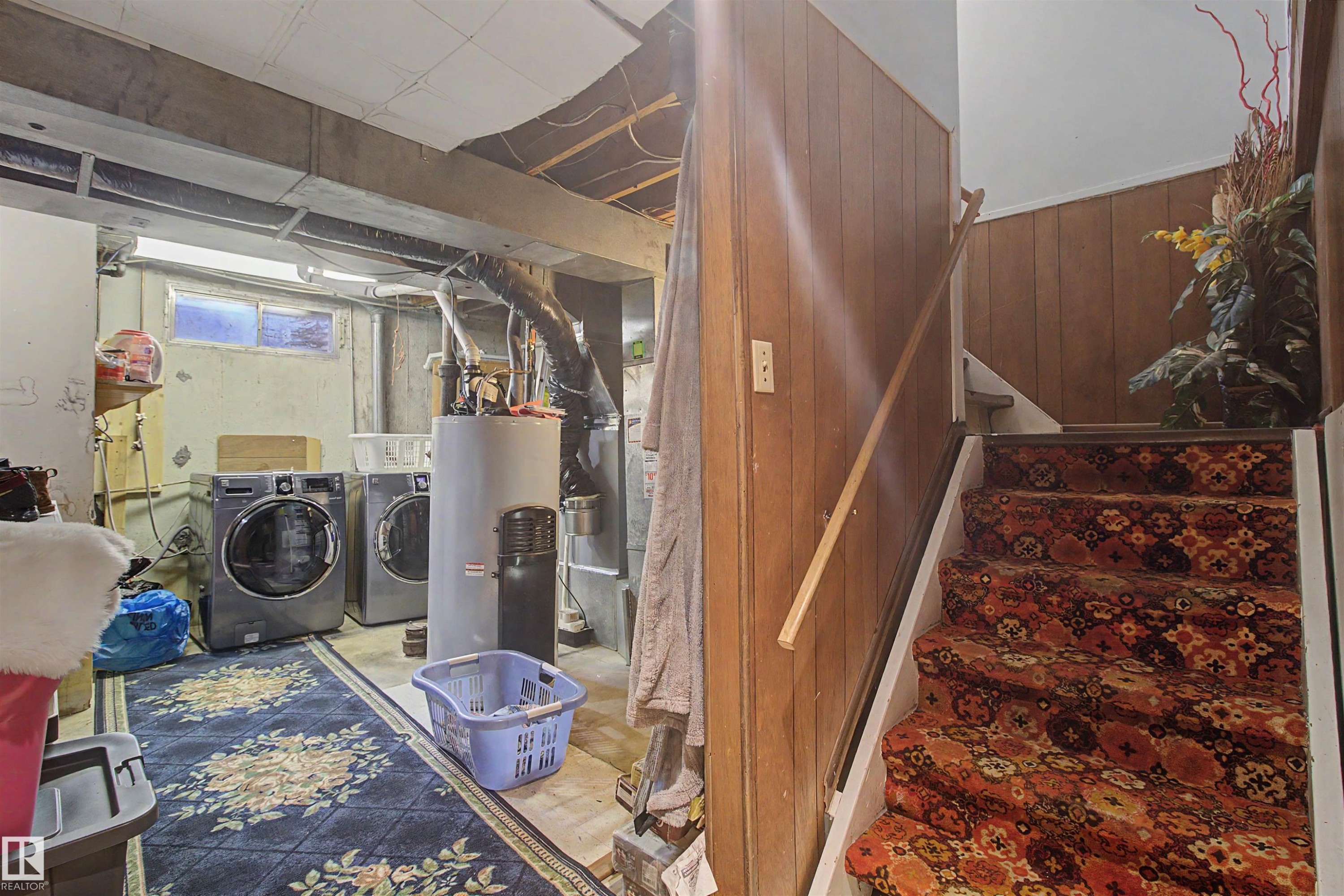 Lower level utility space featuring concrete flooring, exposed ceiling beams, and a water heater - 5724 143 Avenue, Edmonton, AB