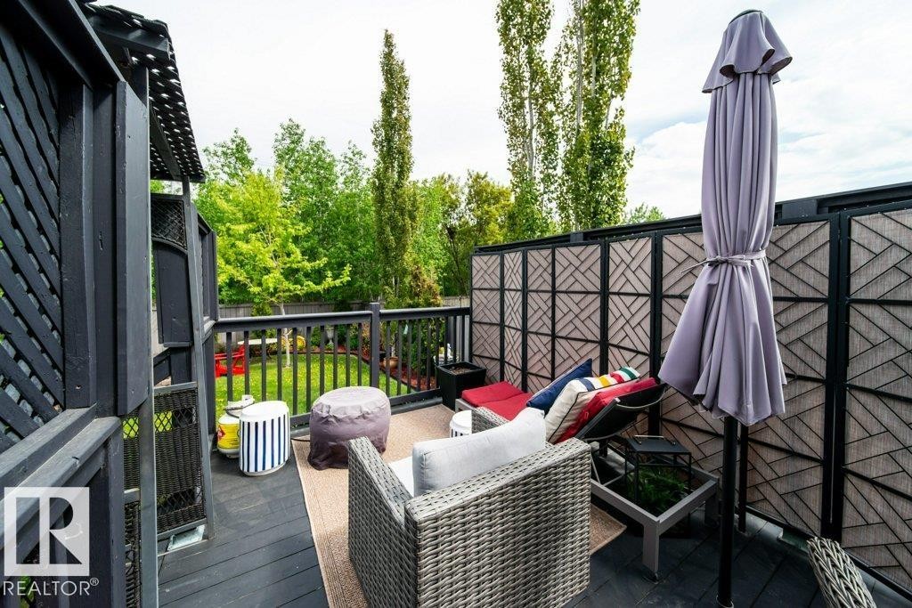 Outdoor deck featuring dark wood flooring, a matching wood railing, and a slatted privacy screen - 8507 2 Avenue Sw, Edmonton, AB - Outdoor With Deck Patio Veranda With Exterior