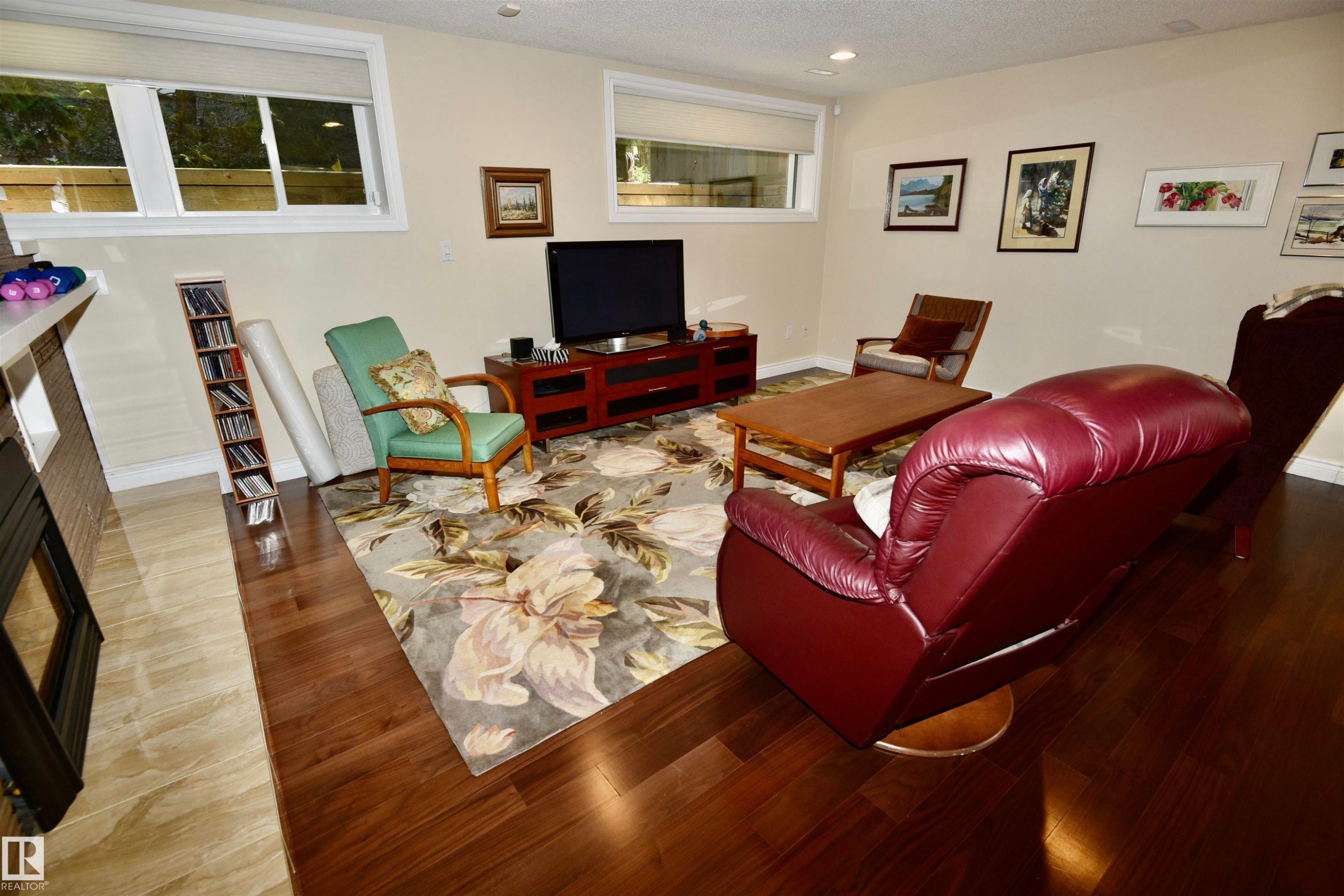 Spacious room featuring rich wood-finish flooring, recessed lighting, and light-toned wall paint - 6 St George'S Crescent, Edmonton, AB