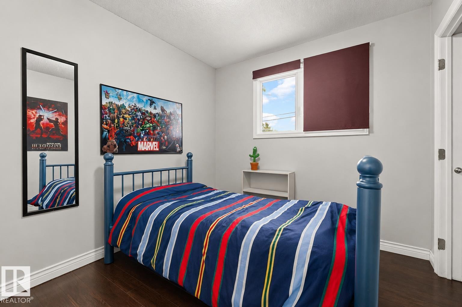 Room featuring a single window with a privacy shade, dark wood-finish flooring, white baseboards, and light-toned walls - 11234 40 Avenue Nw, Edmonton, AB - Indoor Photo Showing Bedroom