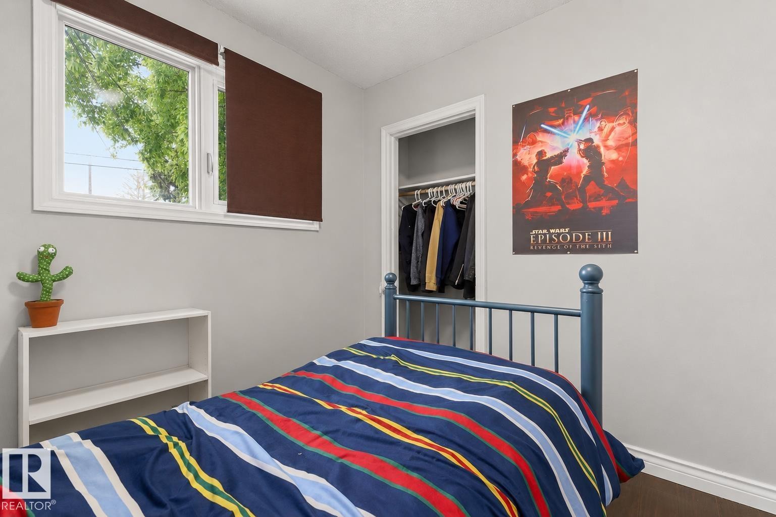 Bedroom featuring a window with brown roller blinds, light gray wall paint, and dark wood-finish flooring - 11234 40 Avenue Nw, Edmonton, AB - Indoor Photo Showing Bedroom