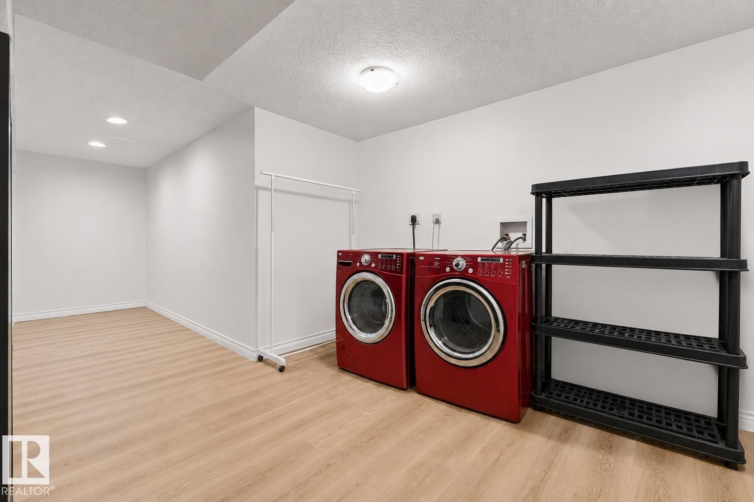 Dedicated laundry area featuring wood-finish flooring and recessed lighting - 11234 40 Avenue Nw, Edmonton, AB - Indoor Photo Showing Laundry Room