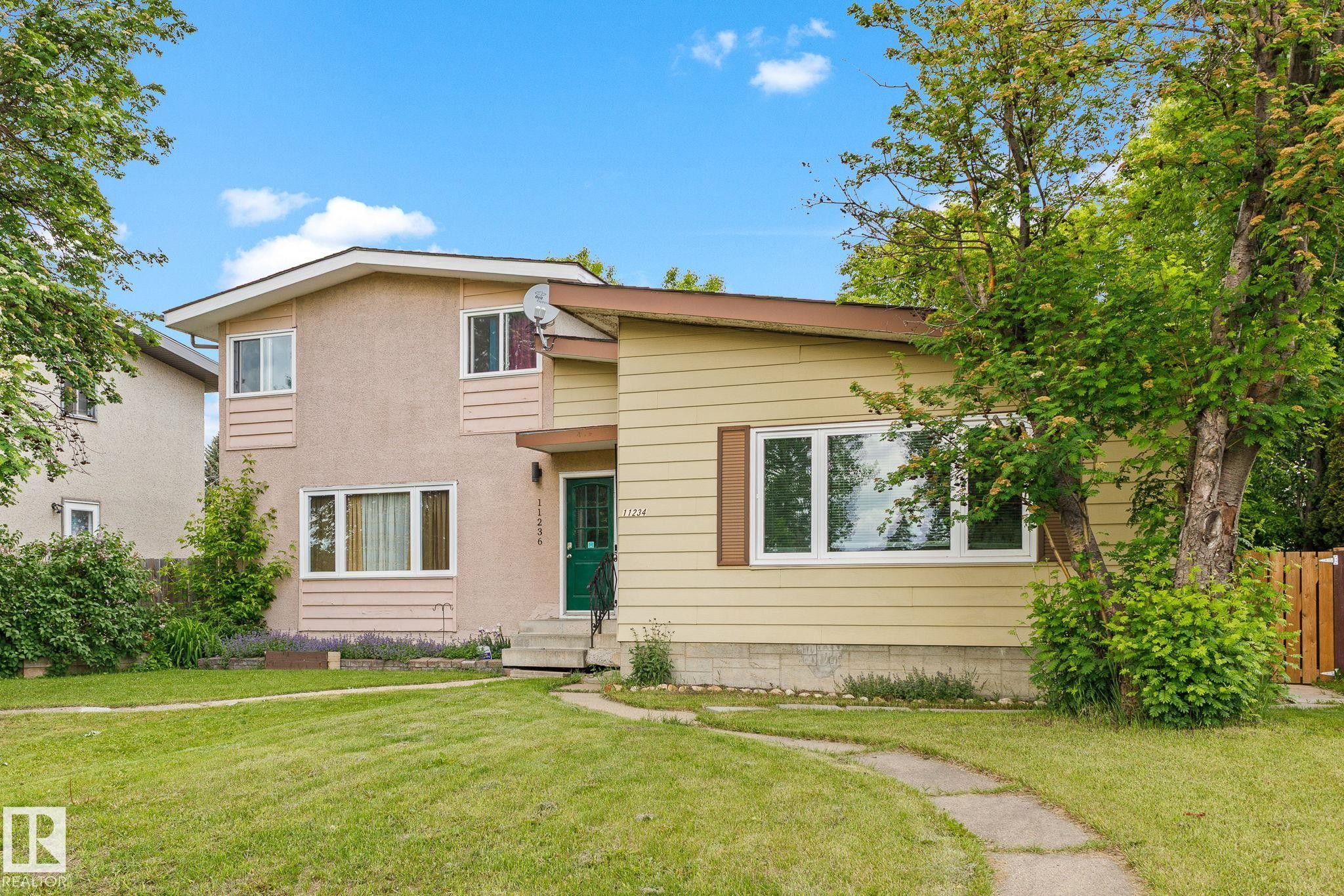 Split-level residence featuring a green entry door and a combination of stucco and horizontal siding finishes - 11234 40 Avenue Nw, Edmonton, AB - Outdoor