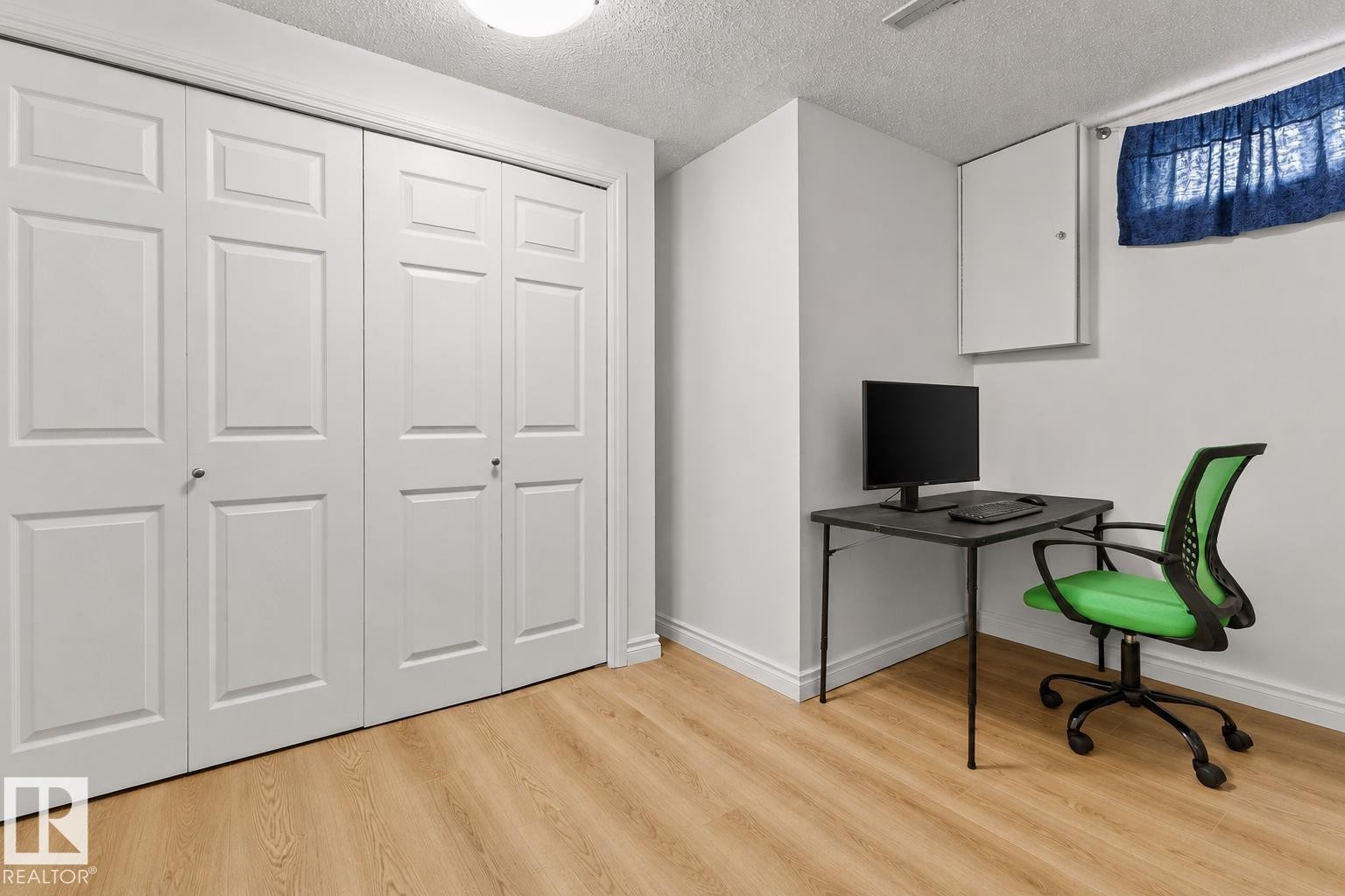 Light wood-finish flooring complements the white baseboards and walls in this bright room - 11234 40 Avenue Nw, Edmonton, AB - Indoor