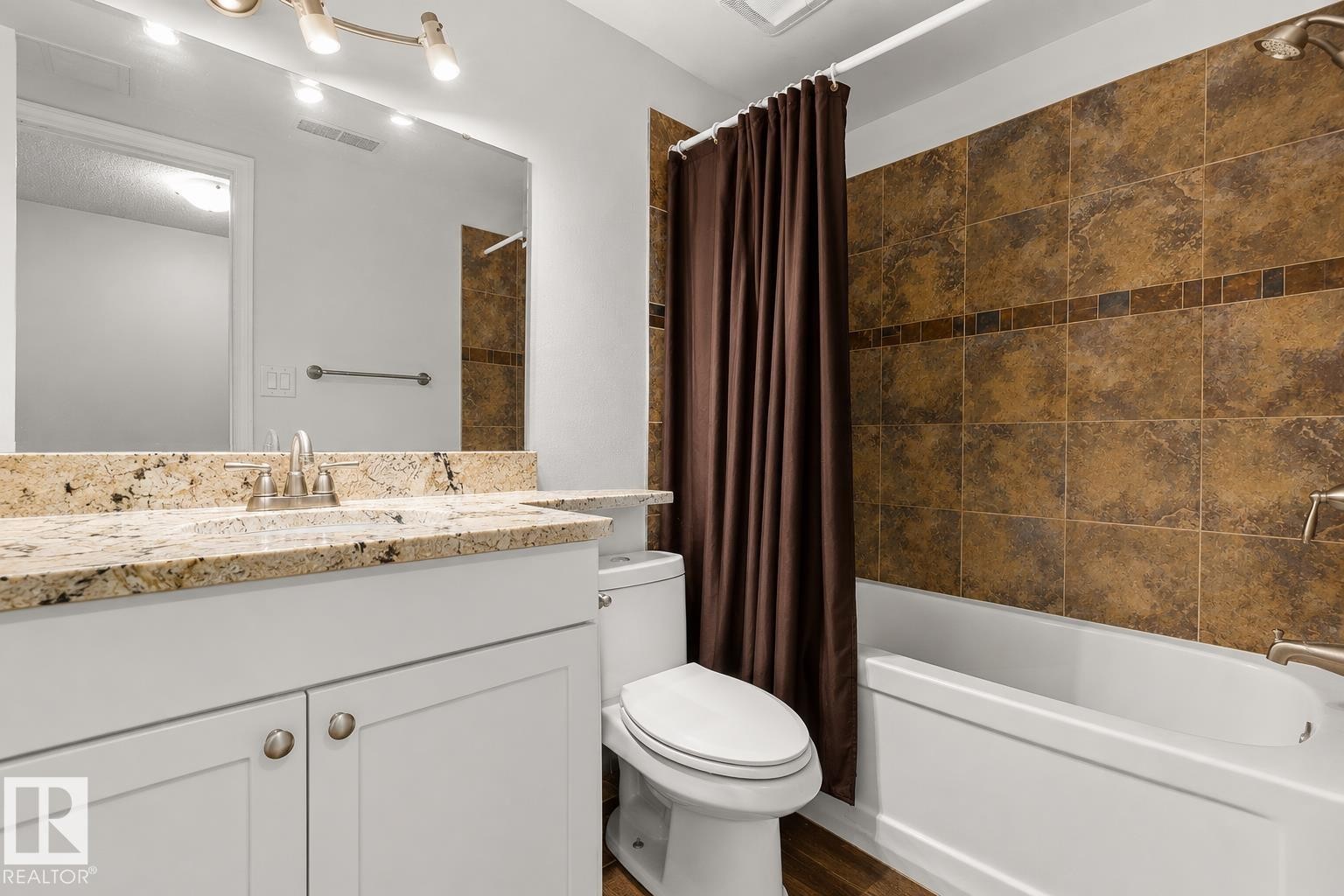 Full bathroom featuring a white vanity with a granite countertop, a built-in sink, and brushed nickel fixtures - 11234 40 Avenue Nw, Edmonton, AB - Indoor Photo Showing Bathroom