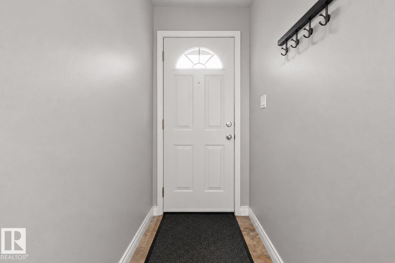 Entryway featuring a white paneled door with an arched glass insert, light gray walls, and light-toned tile flooring - 11234 40 Avenue Nw, Edmonton, AB - Indoor Photo Showing Other Room