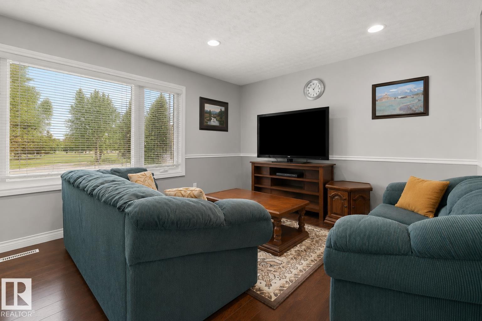 Living area with hardwood-finish flooring and light gray walls featuring white trim - 11234 40 Avenue Nw, Edmonton, AB - Indoor Photo Showing Living Room
