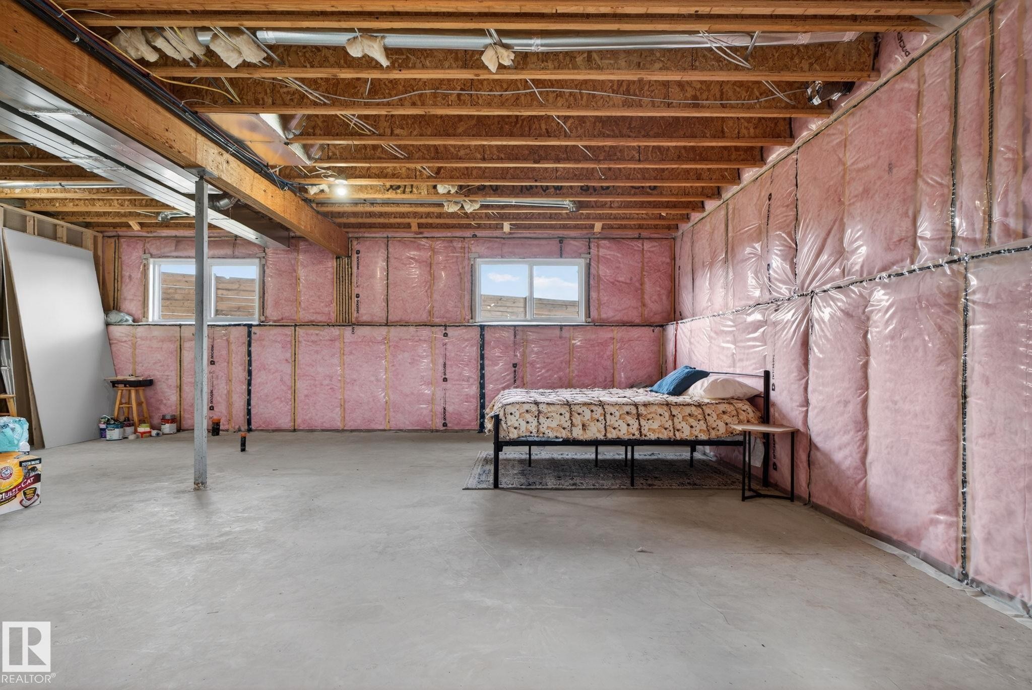 Unfinished basement space featuring exposed wood joists and subfloor, concrete flooring, and insulated walls - 4204 55Av, Lamont, AB