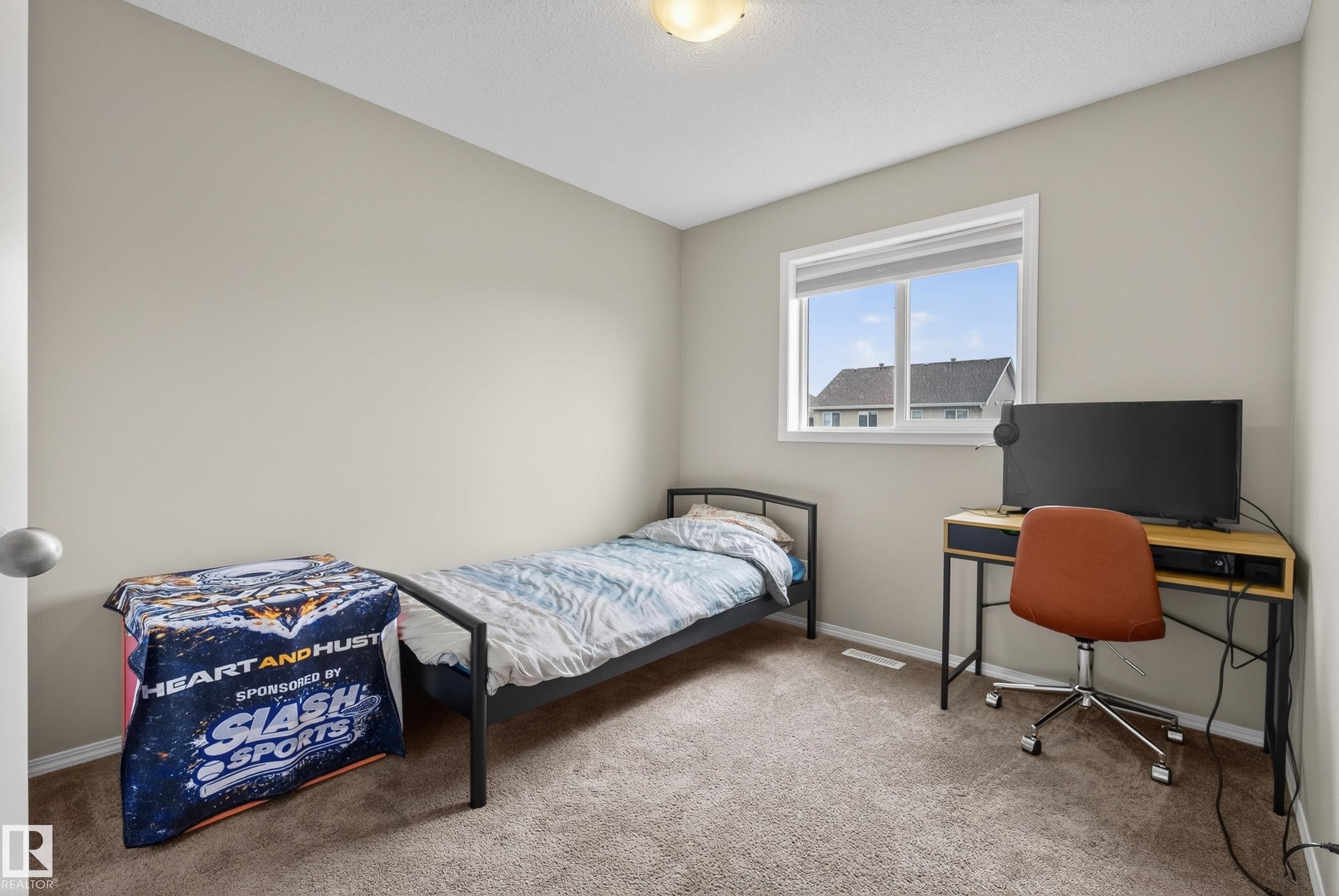Carpeted room with a single window featuring white trim - 2325 69A Street, Edmonton, AB
