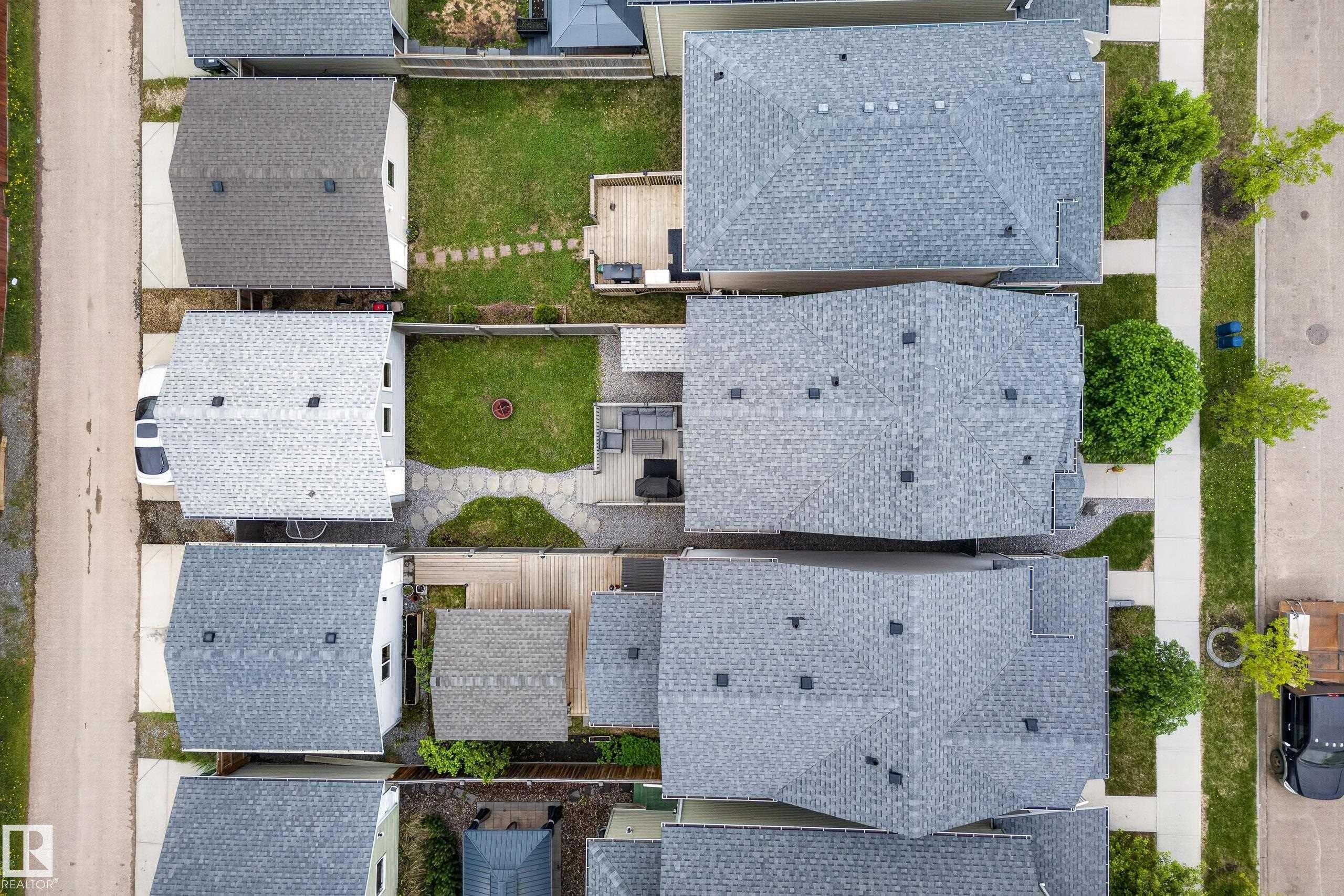 Aerial perspective showcasing multiple properties, each featuring a shingled roof and individual backyard spaces - 2325 69A Street, Edmonton, AB