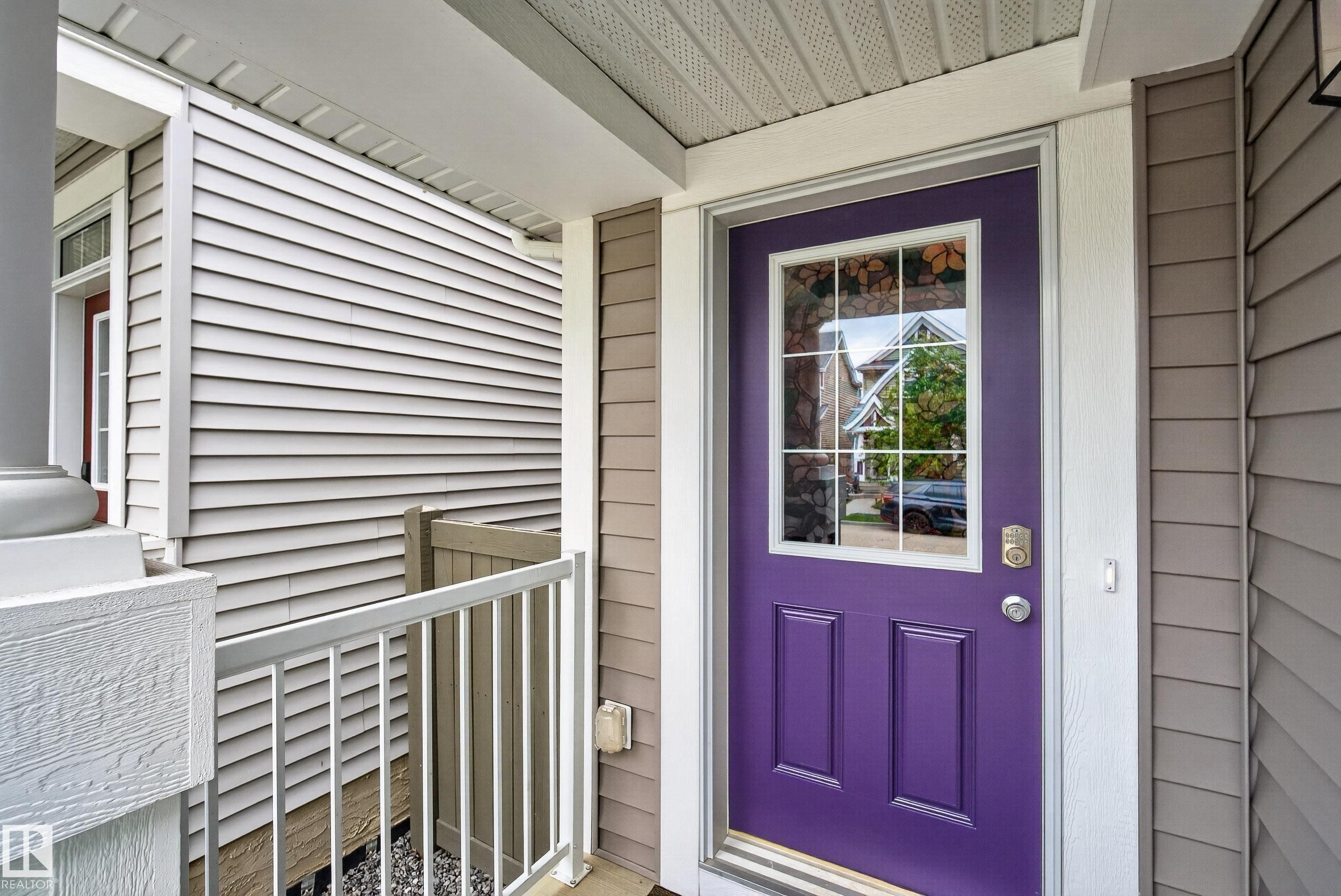 Front entry featuring a paneled door with decorative glass, side panels, and a smart lock - 2325 69A Street, Edmonton, AB