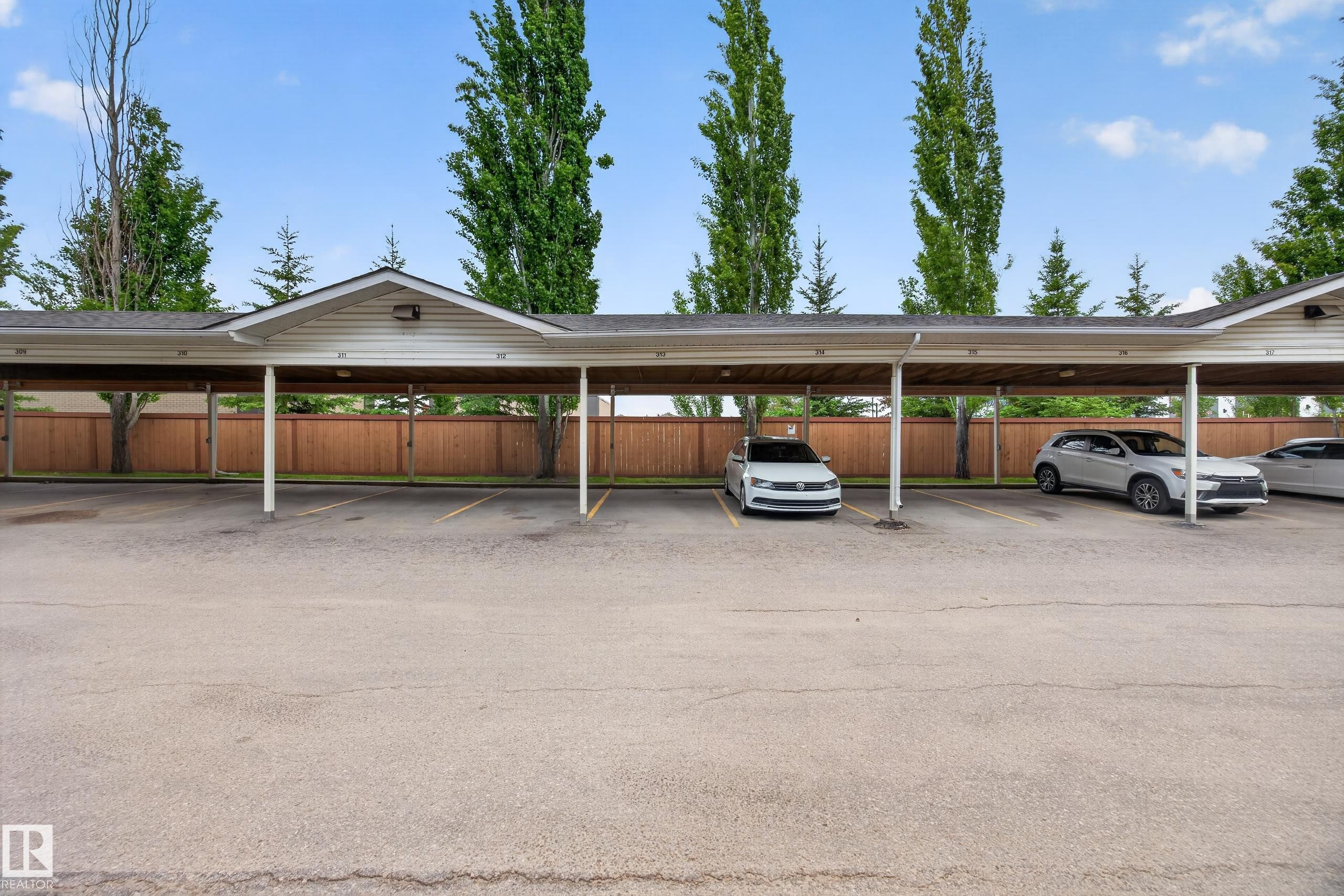Covered parking structure featuring multiple stalls and an asphalt surface - 111 3425 19, Edmonton, AB