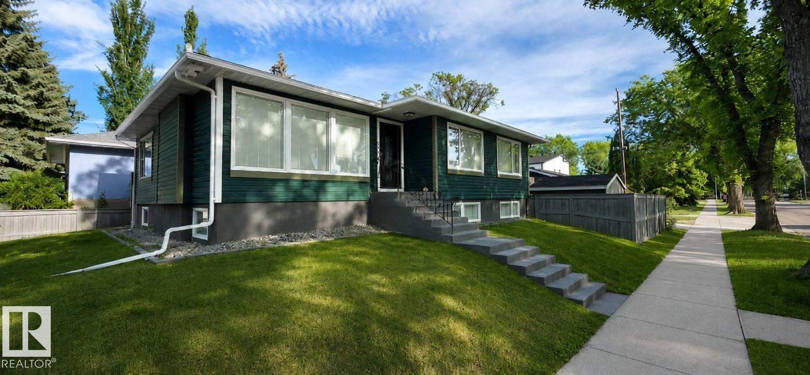 Split-level home featuring dark green siding and a concrete foundation - 6704 93 Street, Edmonton, AB